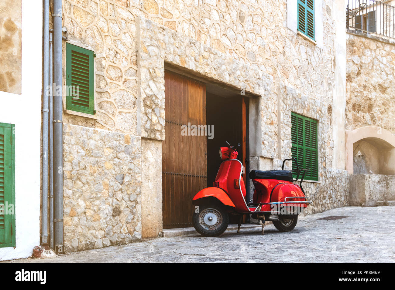 Vintage motocicleta roja estacionada en la histórica aldea española Foto de stock