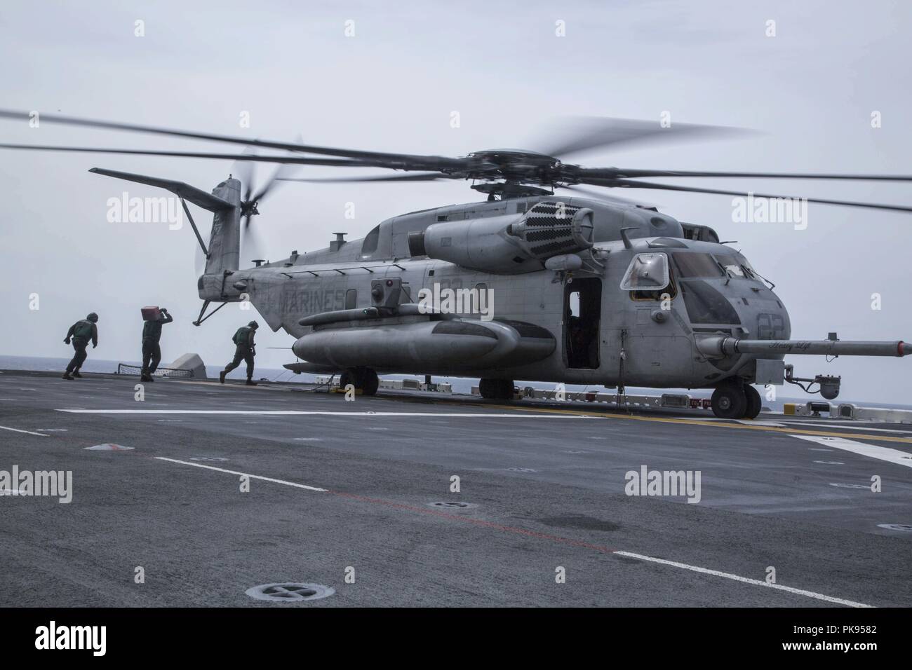 Mar de Mindanao - marineros estadounidenses con el Essex Amphibious Ready Group (ARG) prepare un tipo CH-53E Super Stallion con medio marino Tiltrotor 166 Escuadrón reforzado, 13ª Unidad Expedicionaria de los Infantes de Marina (MEU), para el despegue durante una operación de búsqueda y rescate durante un despliegue programado regularmente de la Essex ARG y 13ª MEU, 11 de agosto de 2018, 11 de agosto de 2018. El Essex ARG/13ª MEU está desplegada actualmente en la séptima Flota de la zona de operaciones. (U. S. Marine Corps foto por CPL. Francisco J. Díaz Jr.). () Foto de stock