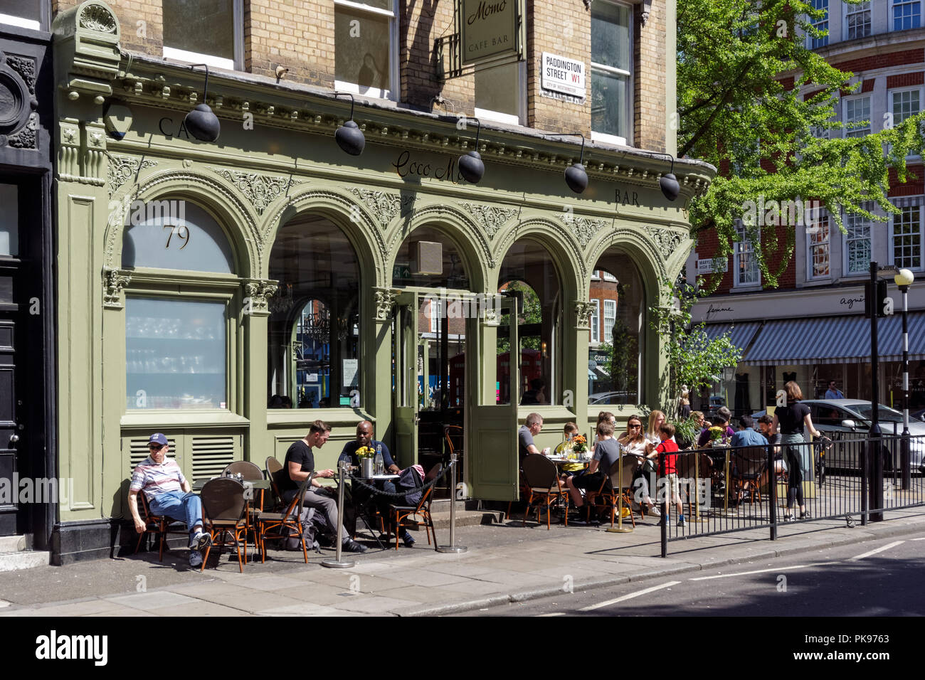Gente sentada fuera de Coco restaurante Momo en Marylebone, Londres, Inglaterra, Reino Unido Foto de stock