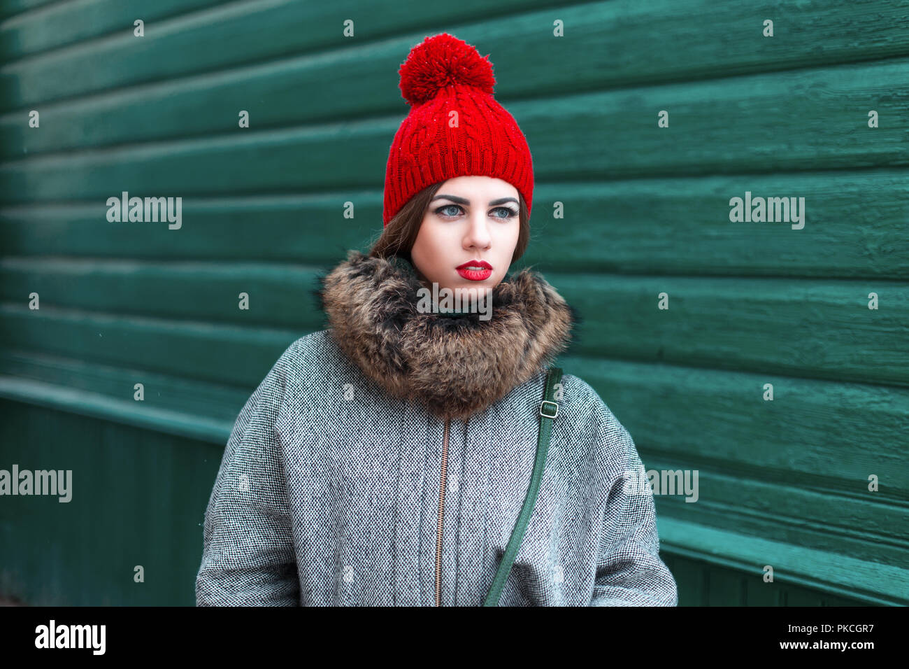 Elegante joven rusa que en moda de invierno ropa de pie cerca de una pared  de madera verde Fotografía de stock - Alamy
