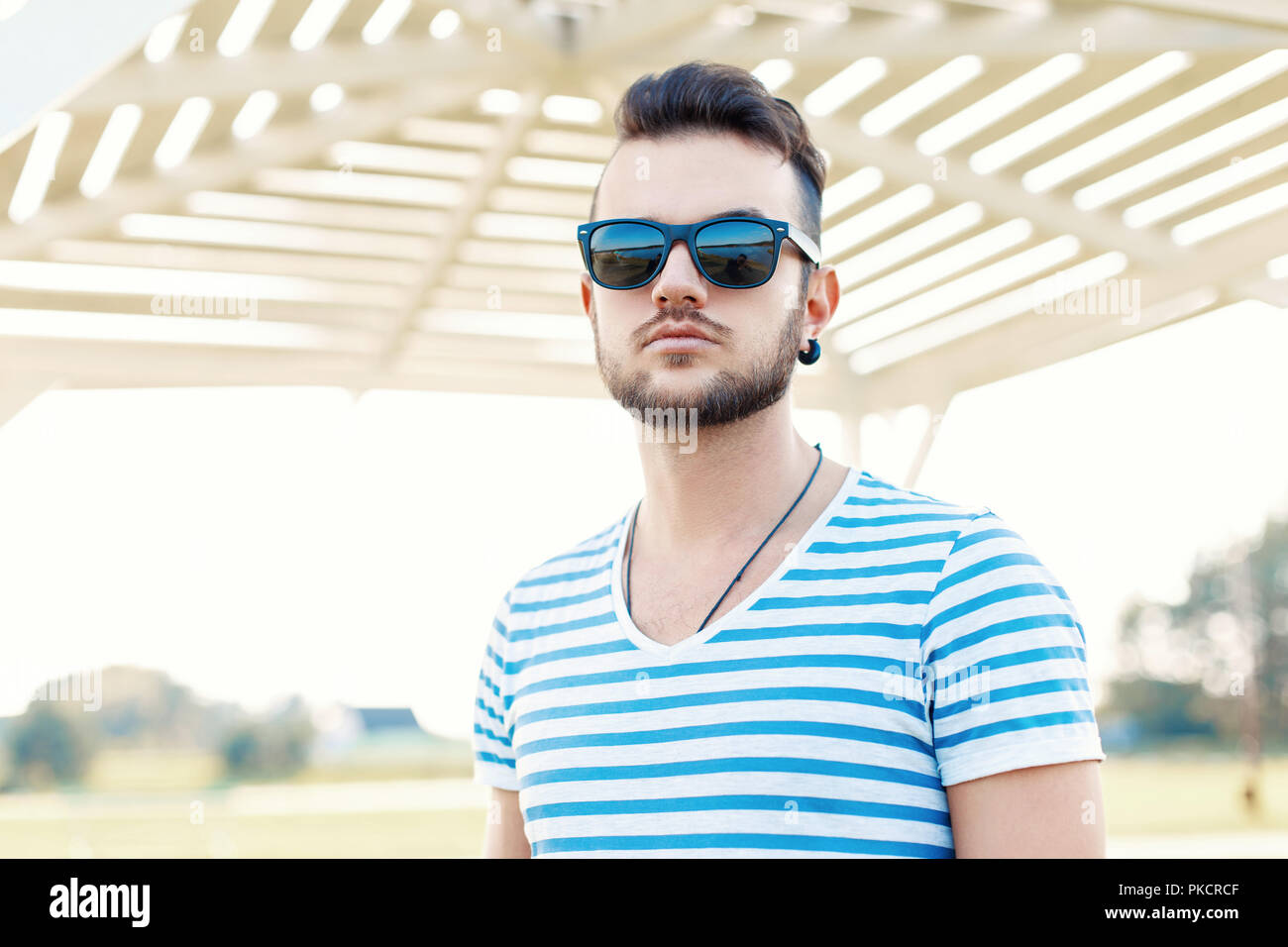 Guapo hipster hombre con barba en gafas de sol en un día soleado en la  playa Fotografía de stock - Alamy