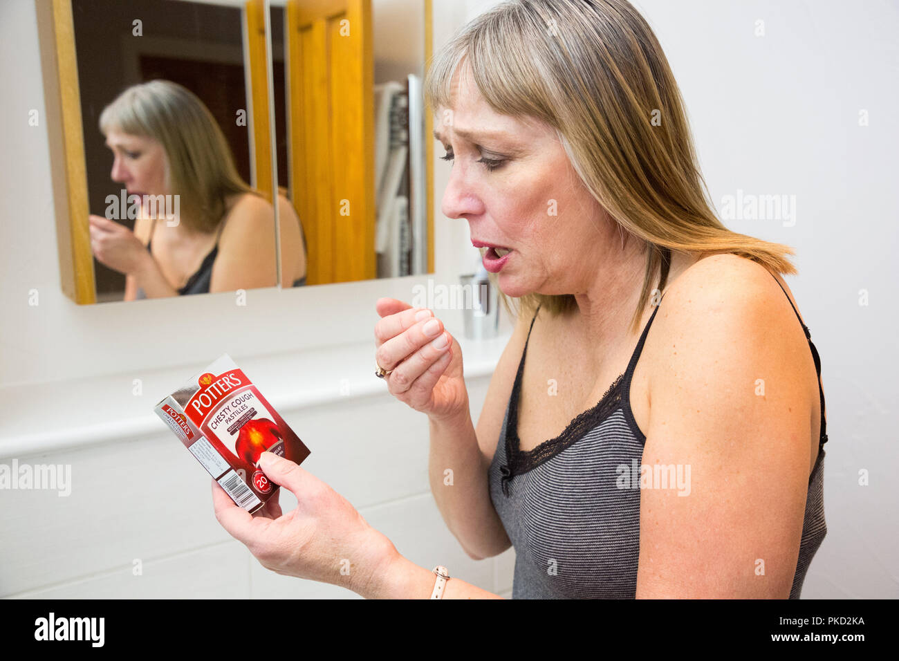 Mujer tosiendo con Potter del medicamento para la tos Foto de stock