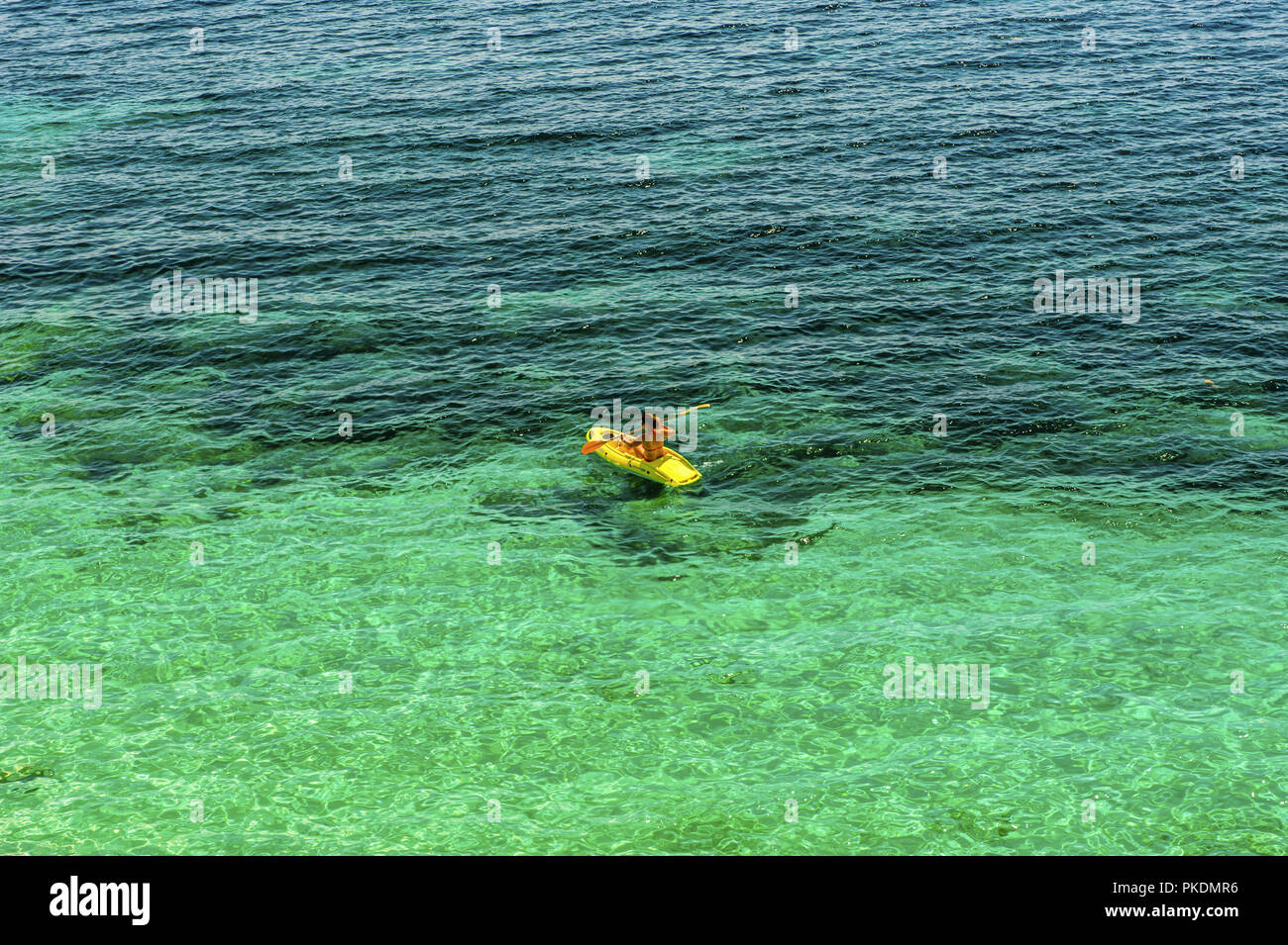 Una sola mujer prácticas en un kayak de mar kayak amarillo Foto de stock