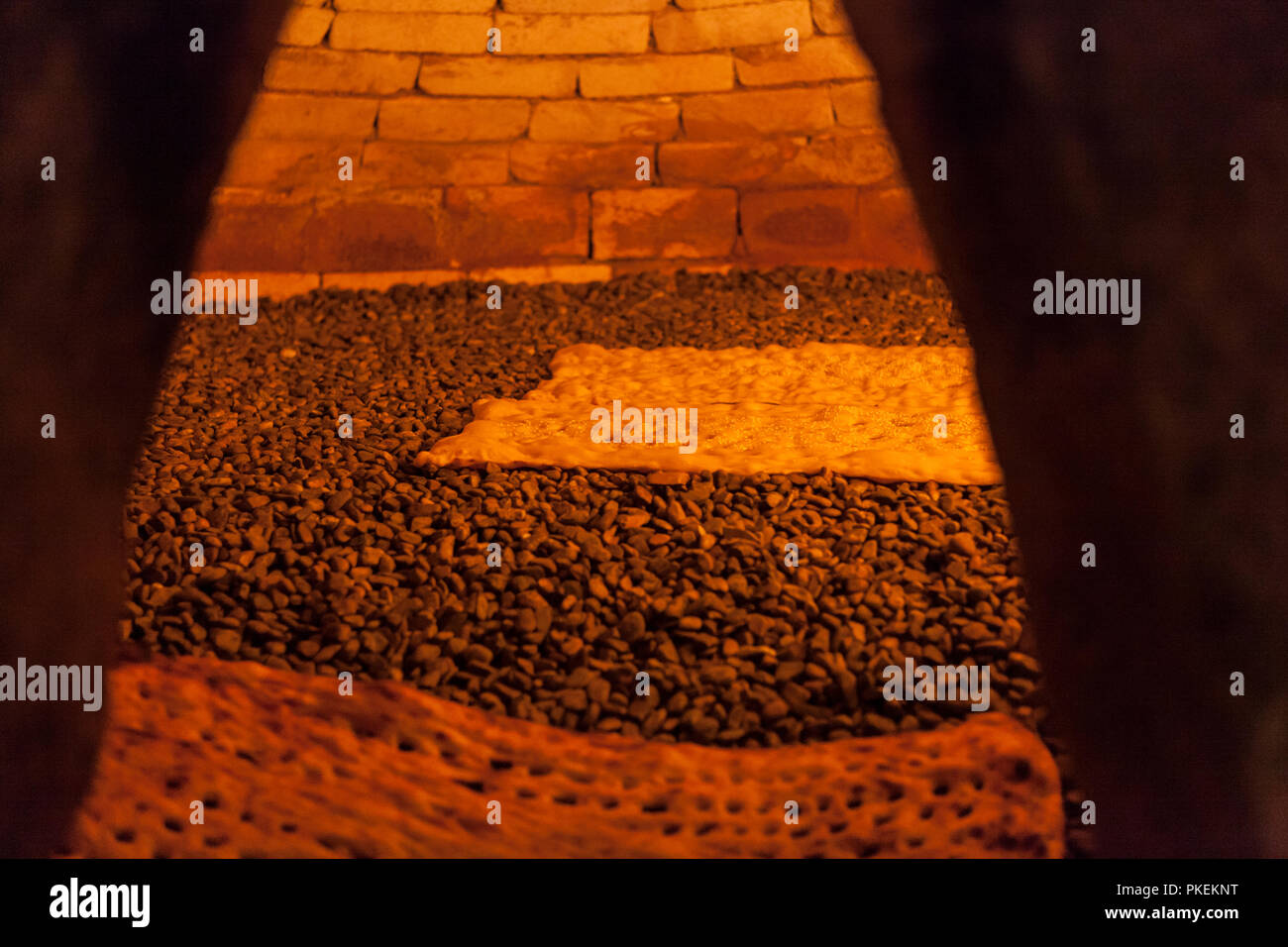 Sangak, un leudado flatbread Iraní, siendo horneados en piedras pequeñas en  un horno tradicional. En persa 'angak' significa piedra pequeña Fotografía  de stock - Alamy