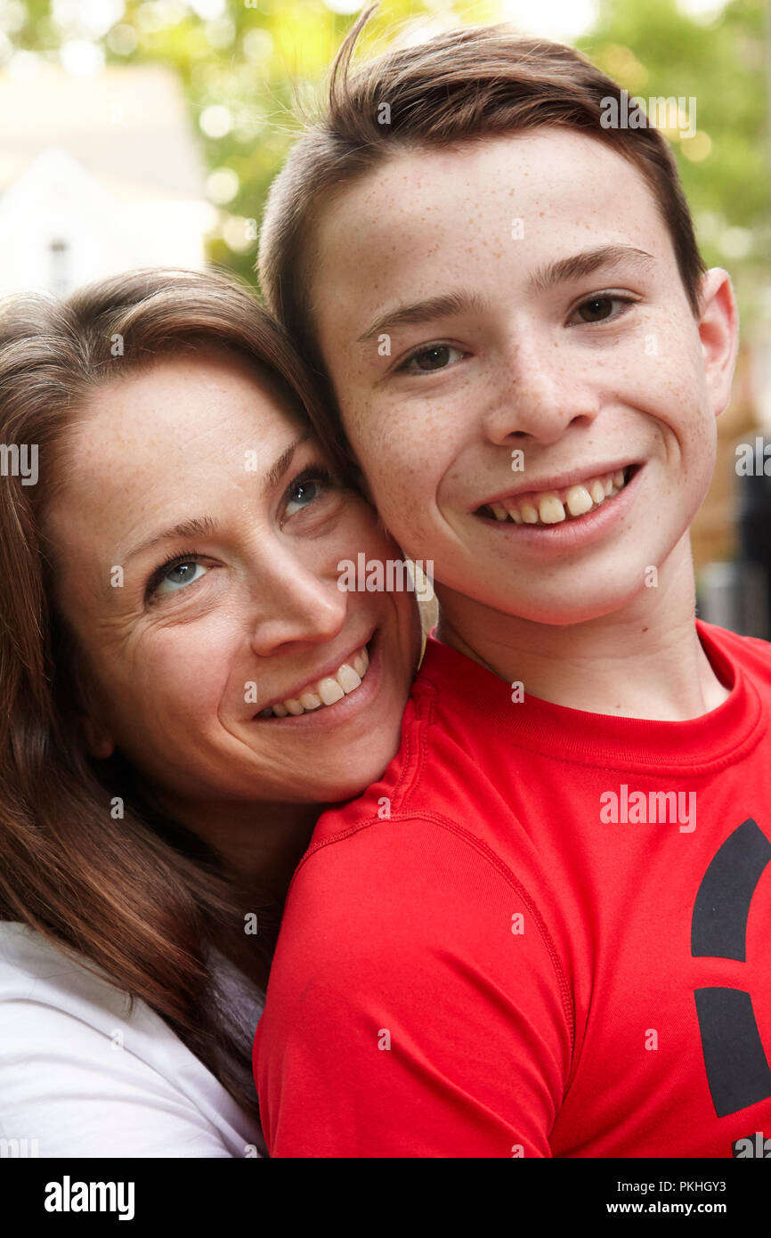 Hijo sentado en el regazo de las madres sonriendo Foto de stock