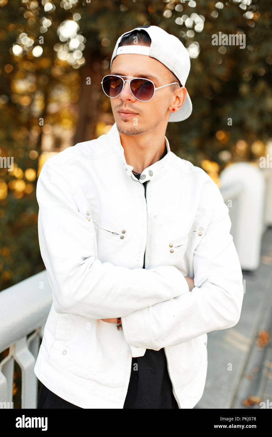 Un joven apuesto y en gafas de de moda en ropa blanca en un soleado día de otoño Fotografía de stock - Alamy