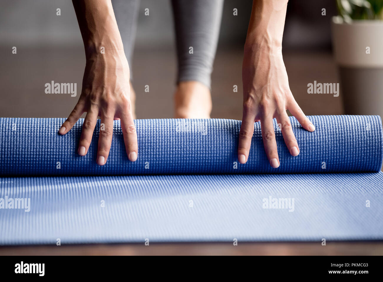 Las niñas mano azul plegable colchoneta de ejercicios en el suelo Foto de stock