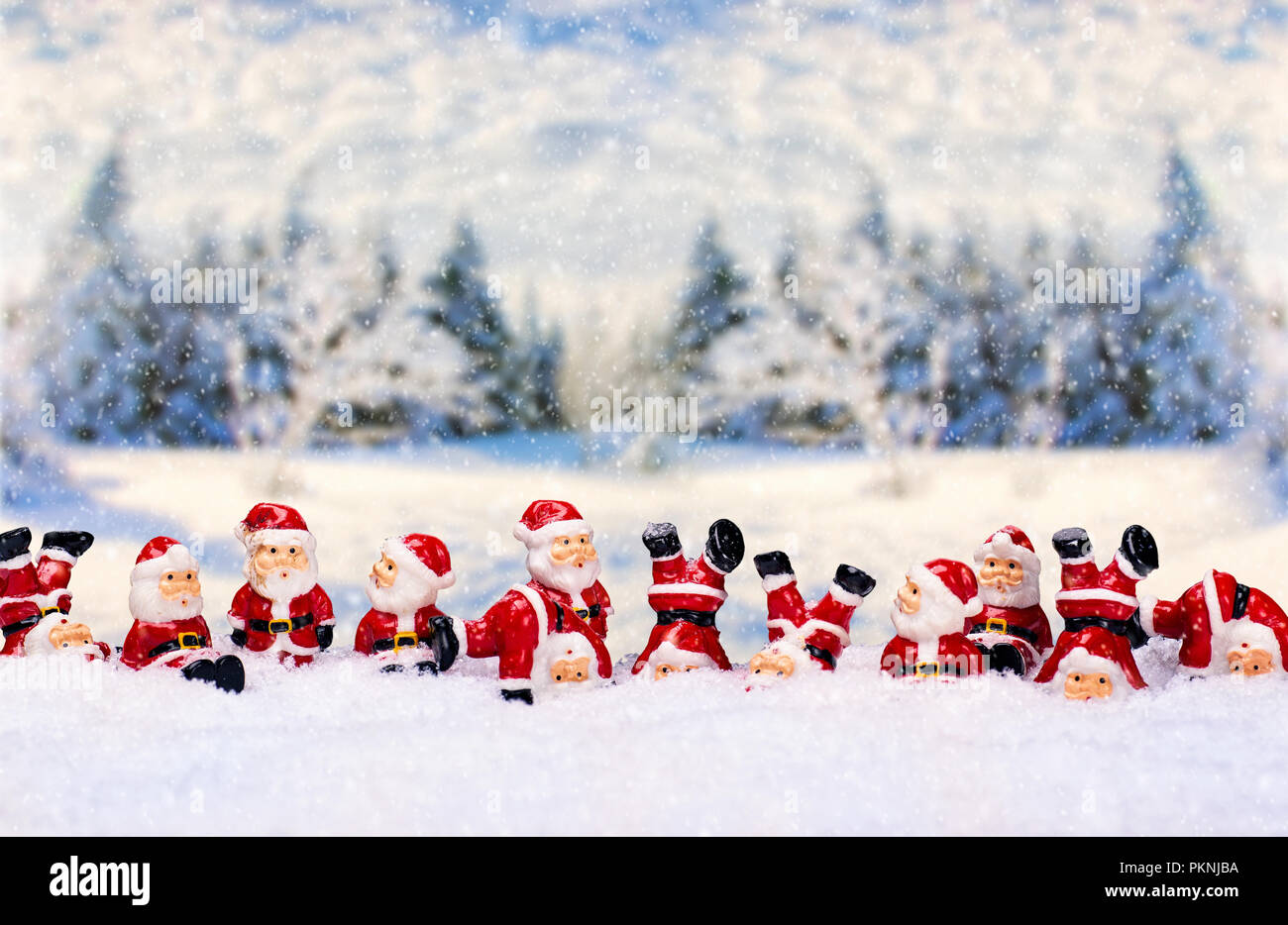Un gran número de figuras de Santa Claus delante de un paisaje de invierno Foto de stock