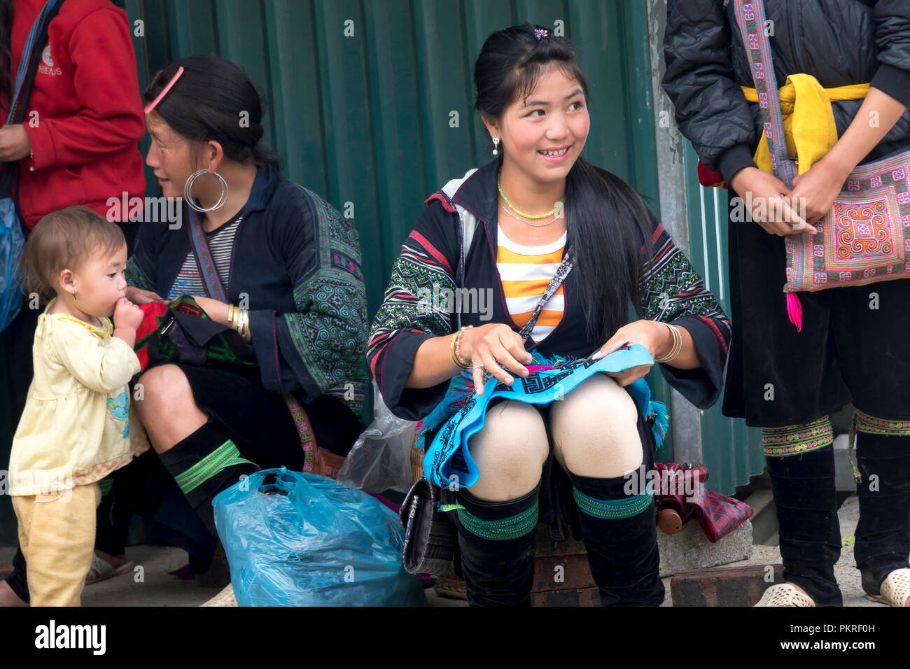 La imagen de la hermosa muchacha de la minoría H'Mong está sentado en bordado en Sapa town, Lao Cai, Vietnam Foto de stock
