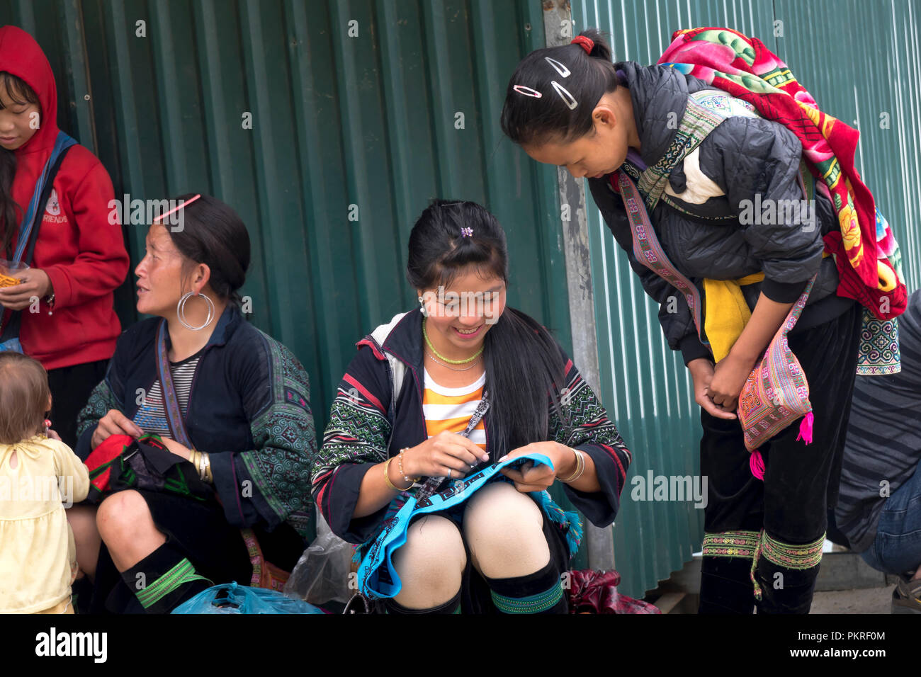 La imagen de la hermosa muchacha de la minoría H'Mong está sentado en bordado en Sapa town, Lao Cai, Vietnam Foto de stock