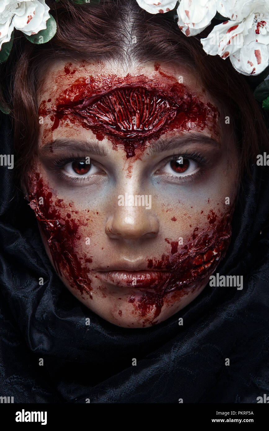 Ejecución puede cuadrado Retrato de bloody horrible miedo zombie girl en un maquillaje de fiesta de  Halloween. Los ojos rojos Fotografía de stock - Alamy