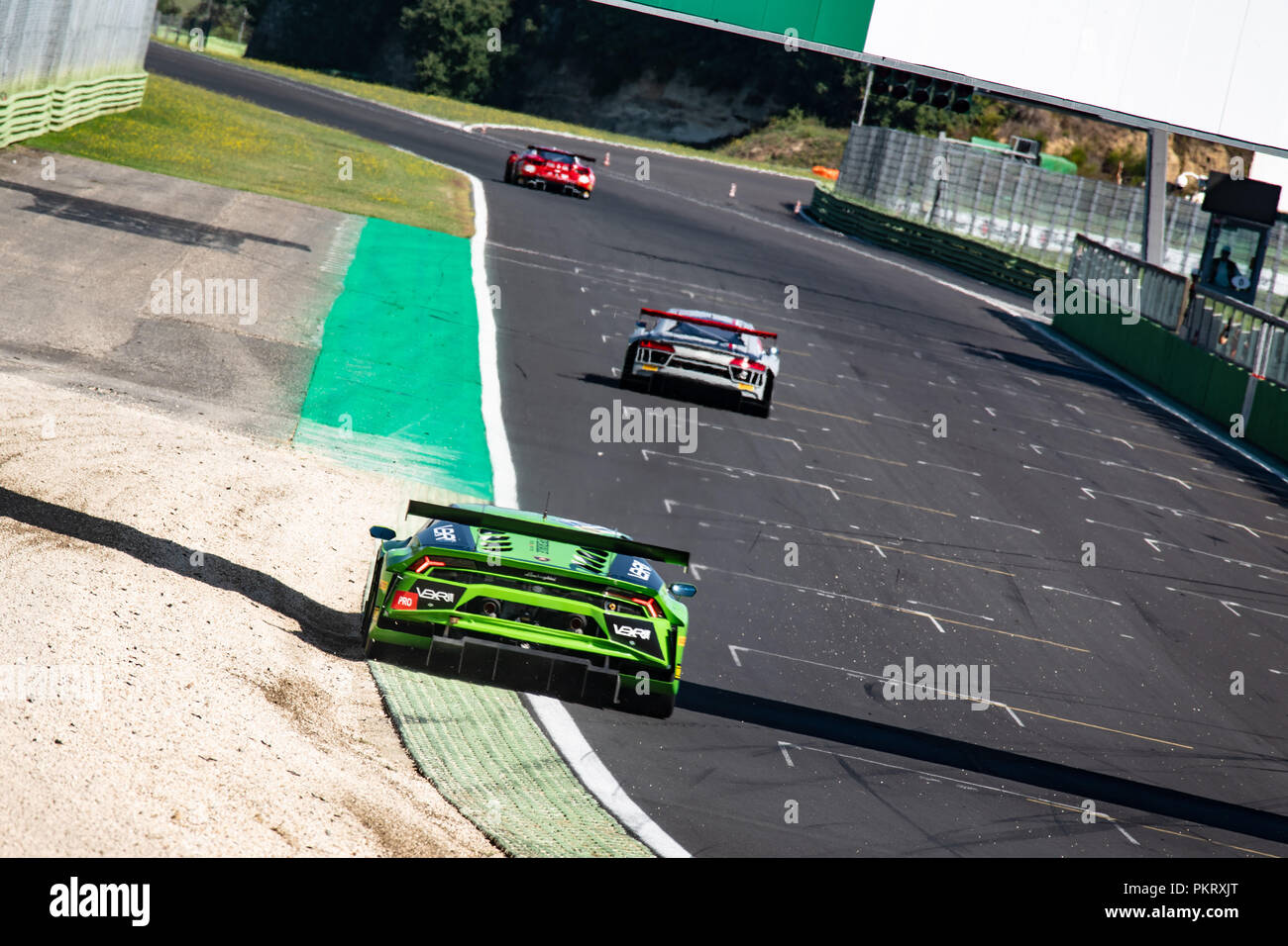 Plano amplio de Lamborghini Touring Car en acción vista trasera de las esquinas en circuito de carreras Foto de stock