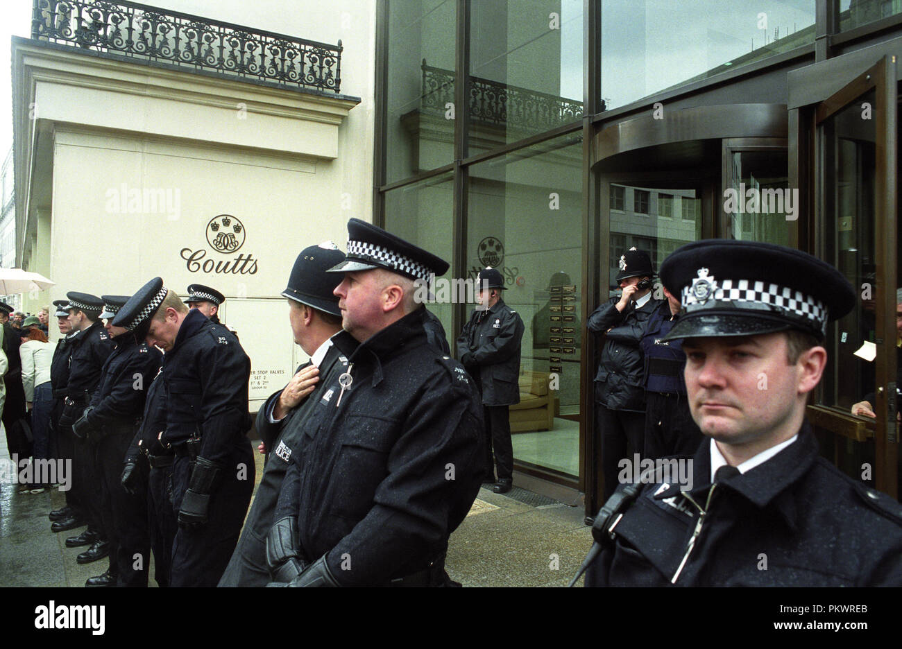 La policía protege una rama de Coutts Bank durante mayo Día contra manifestaciones en Londres el 1 de mayo de 2001 Foto de stock
