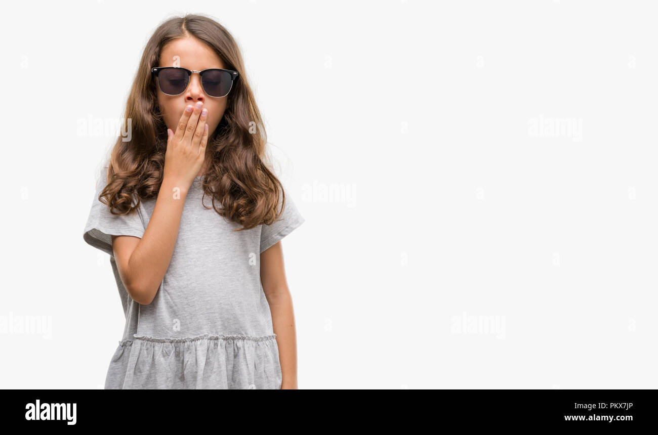 Morena chica hispana con gafas de sol aburrido bostezo cansado cubriendo la boca con la mano. Inquieto y somnolencia. Foto de stock