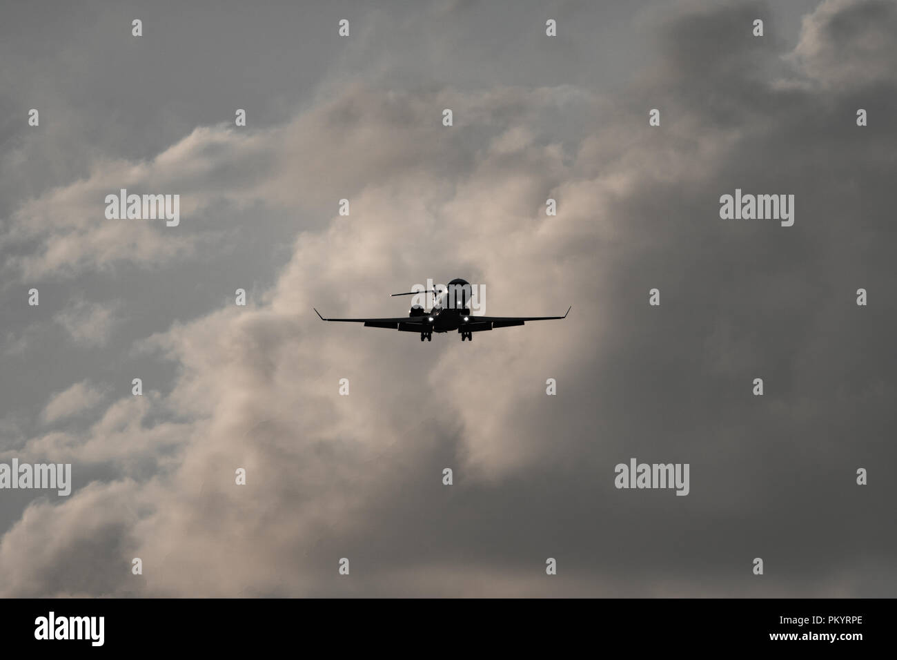 Alto contraste de avión de reacción contra las nubes Foto de stock
