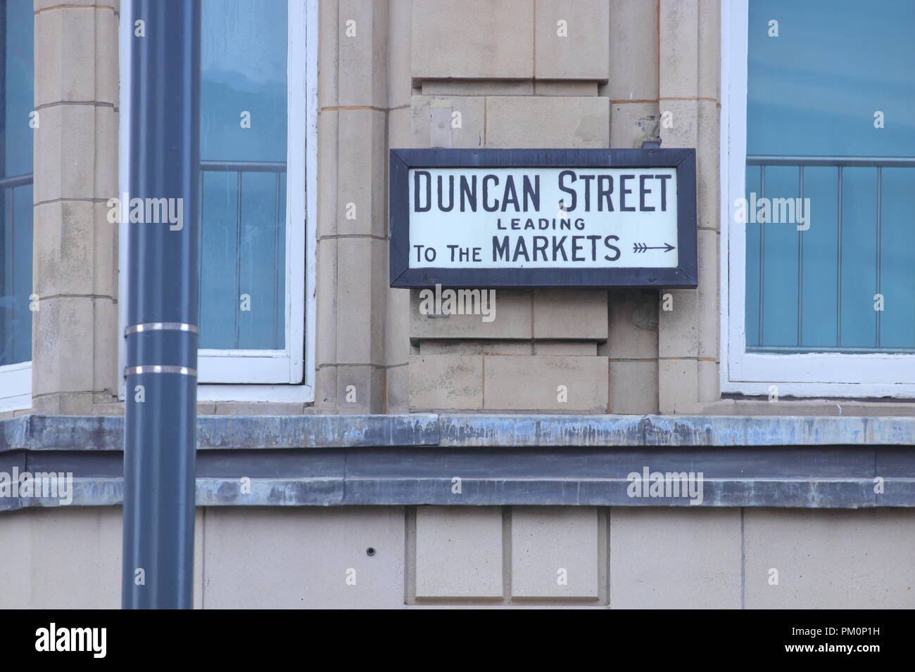 Un cartel con el nombre de la calle con indicaciones para llegar a los mercados en Leeds. Foto de stock