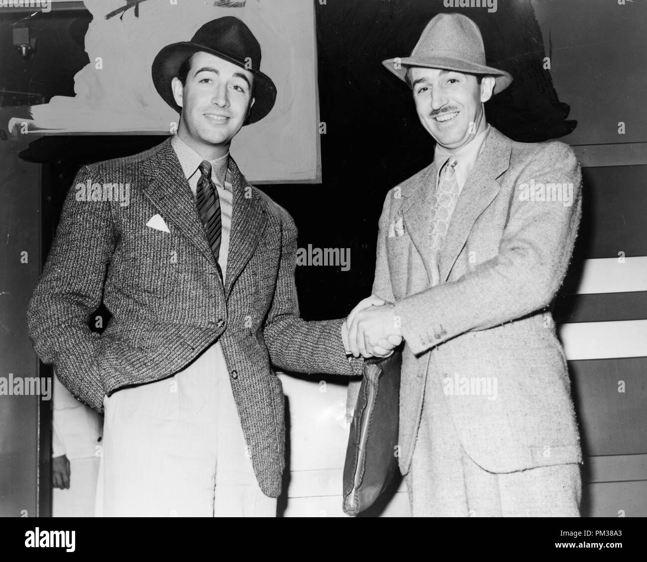 Walt Disney se da la mano con Robert Taylor, tres cuartos de longitud retratos, 1938. Archivo de referencia # 1184 001tha Foto de stock