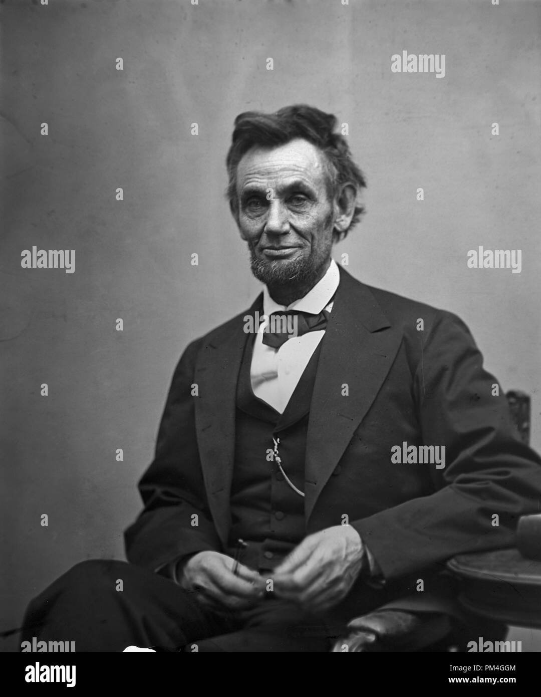 Abraham Lincoln, tres cuartos de longitud vertical, sentado y sosteniendo sus anteojos y un lápiz. El 5 de febrero de 1865. Archivo de referencia # 1003 012tha Foto de stock