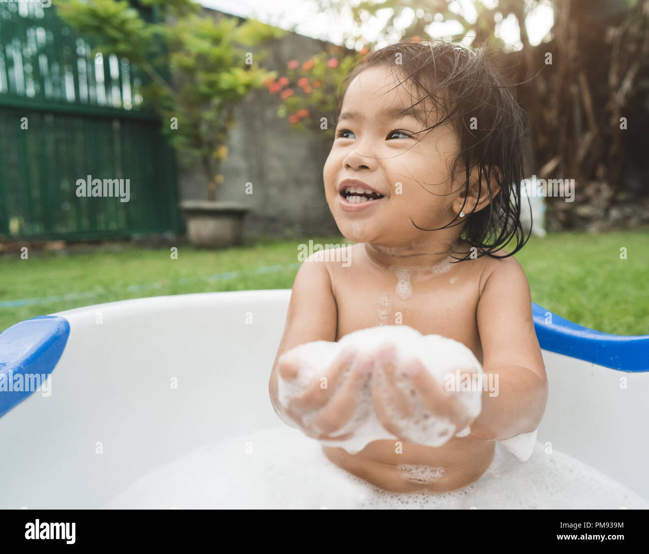 Hermosa niña tomar un baño de espuma de jabón y jugar en un bebé Fotografía  de stock - Alamy