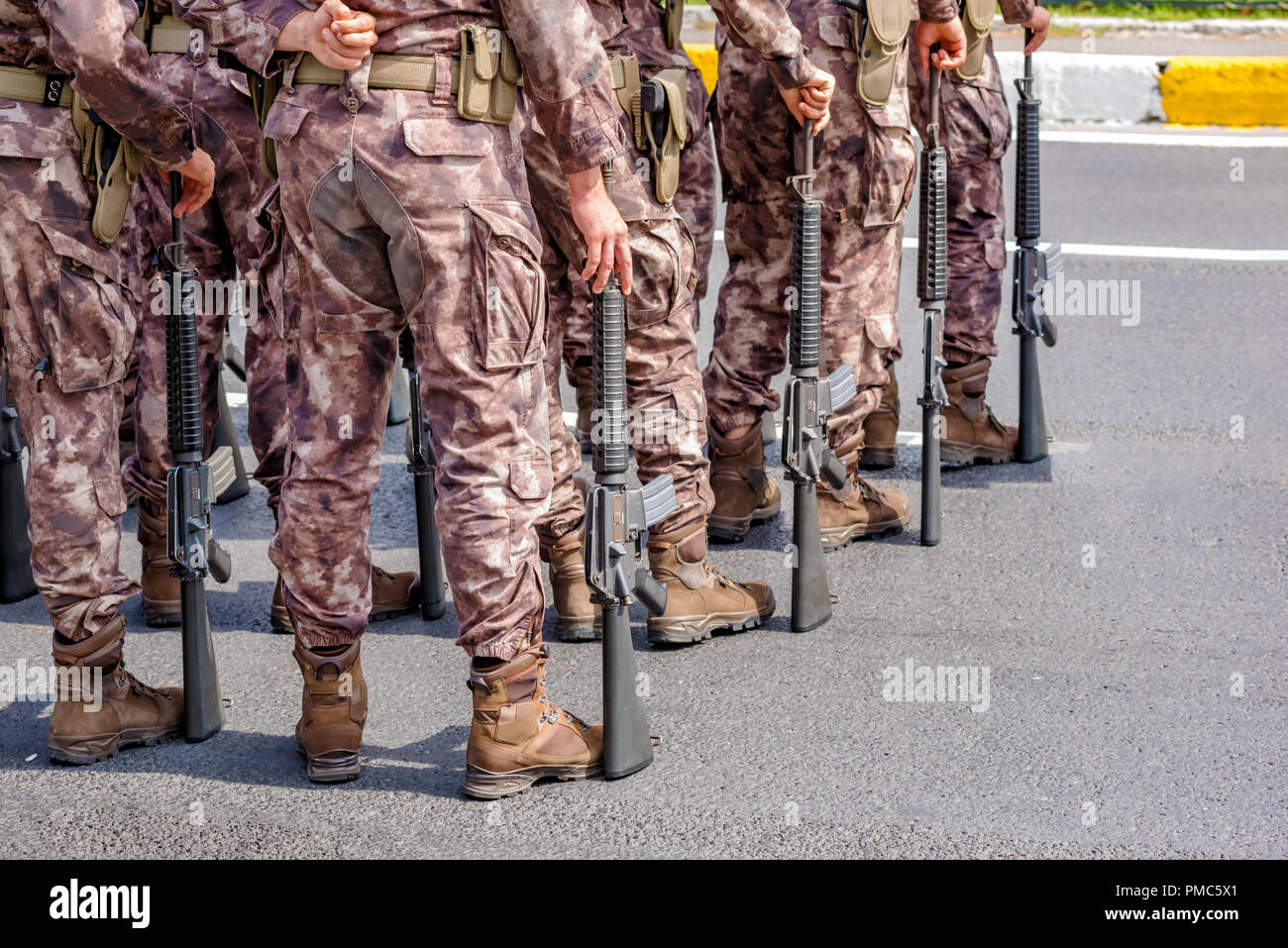 Soldados permanecen en fila con la pistola en la mano. El ejército, las botas  militares de líneas de comandos de soldados en uniformes de camuflaje  Fotografía de stock - Alamy
