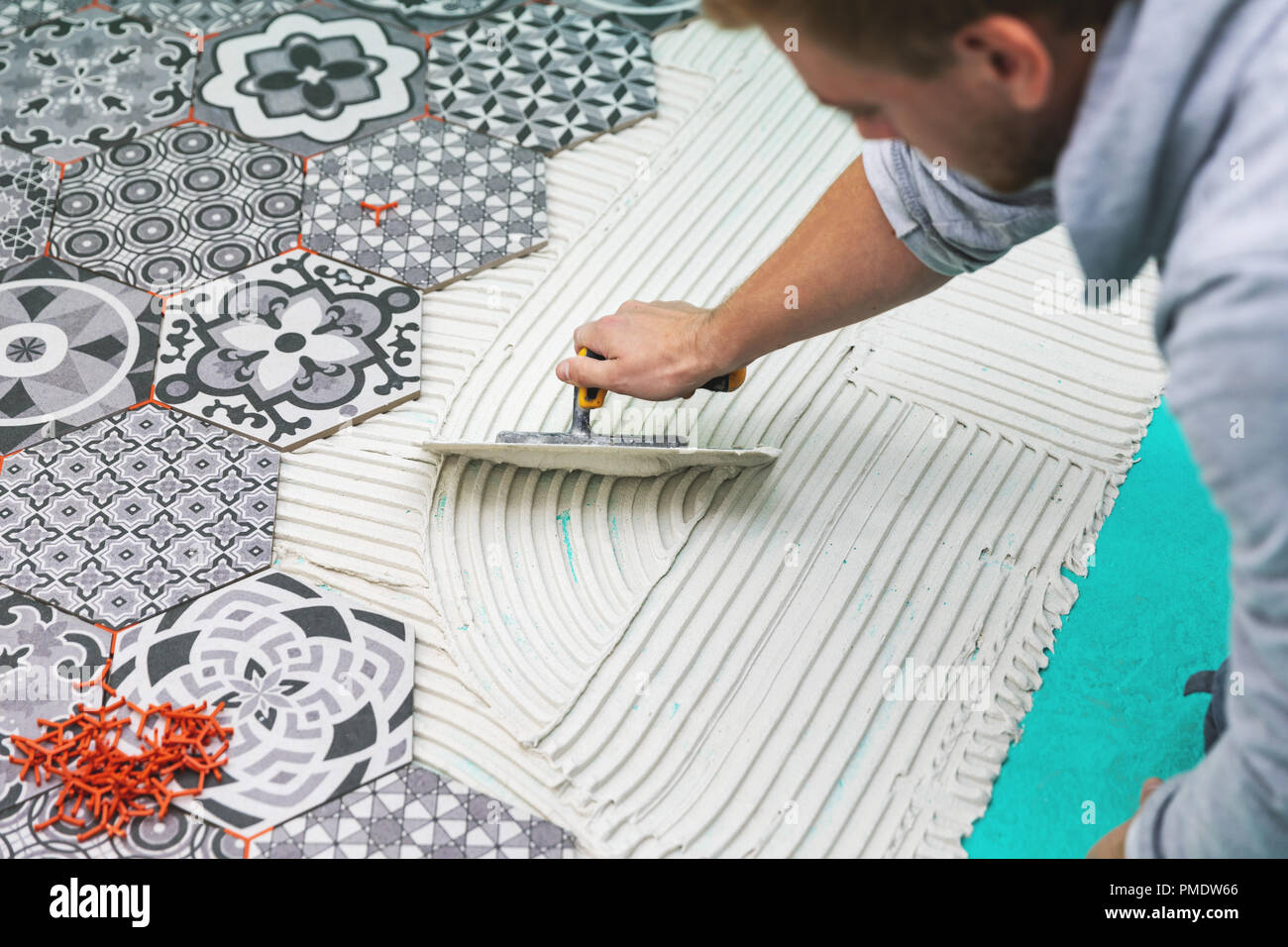 Trabajador aplicar adhesivo sobre el piso de mosaico Foto de stock