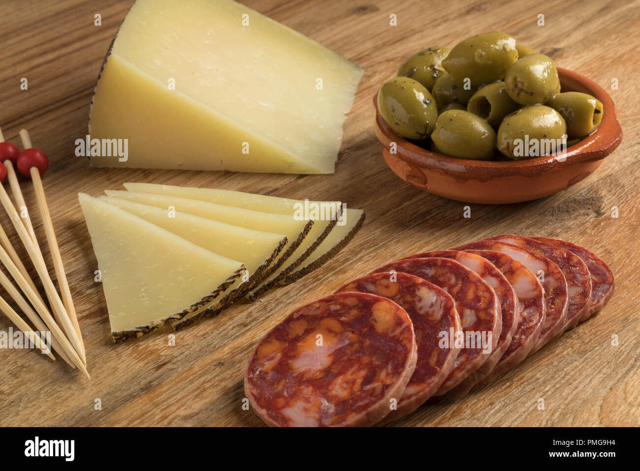 El queso Manchego tradicional española, con chorizo y aceitunas como tapas Foto de stock