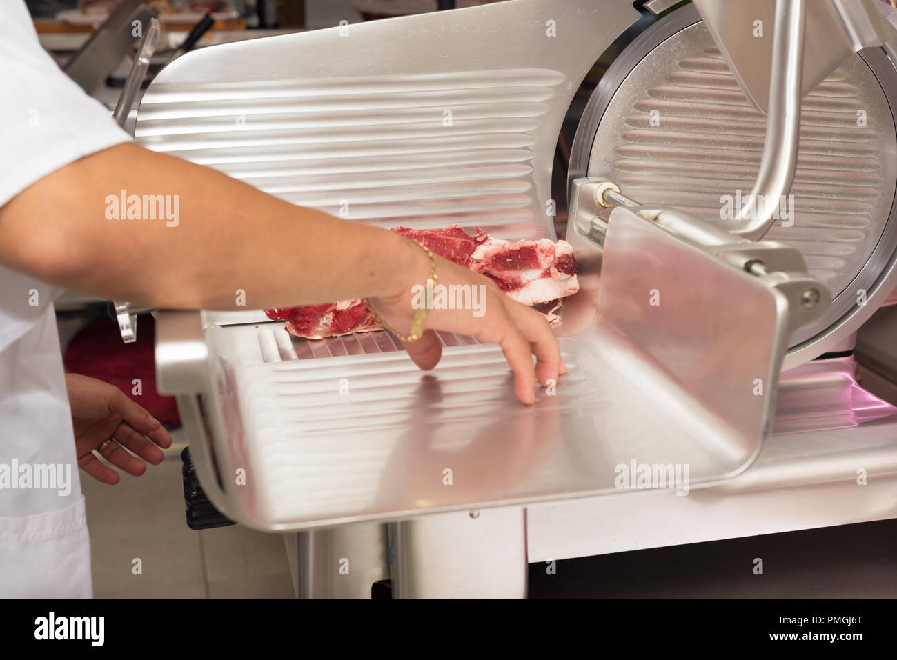 Carnicero cortando la carne en la carnicería. Cerrar Foto de stock