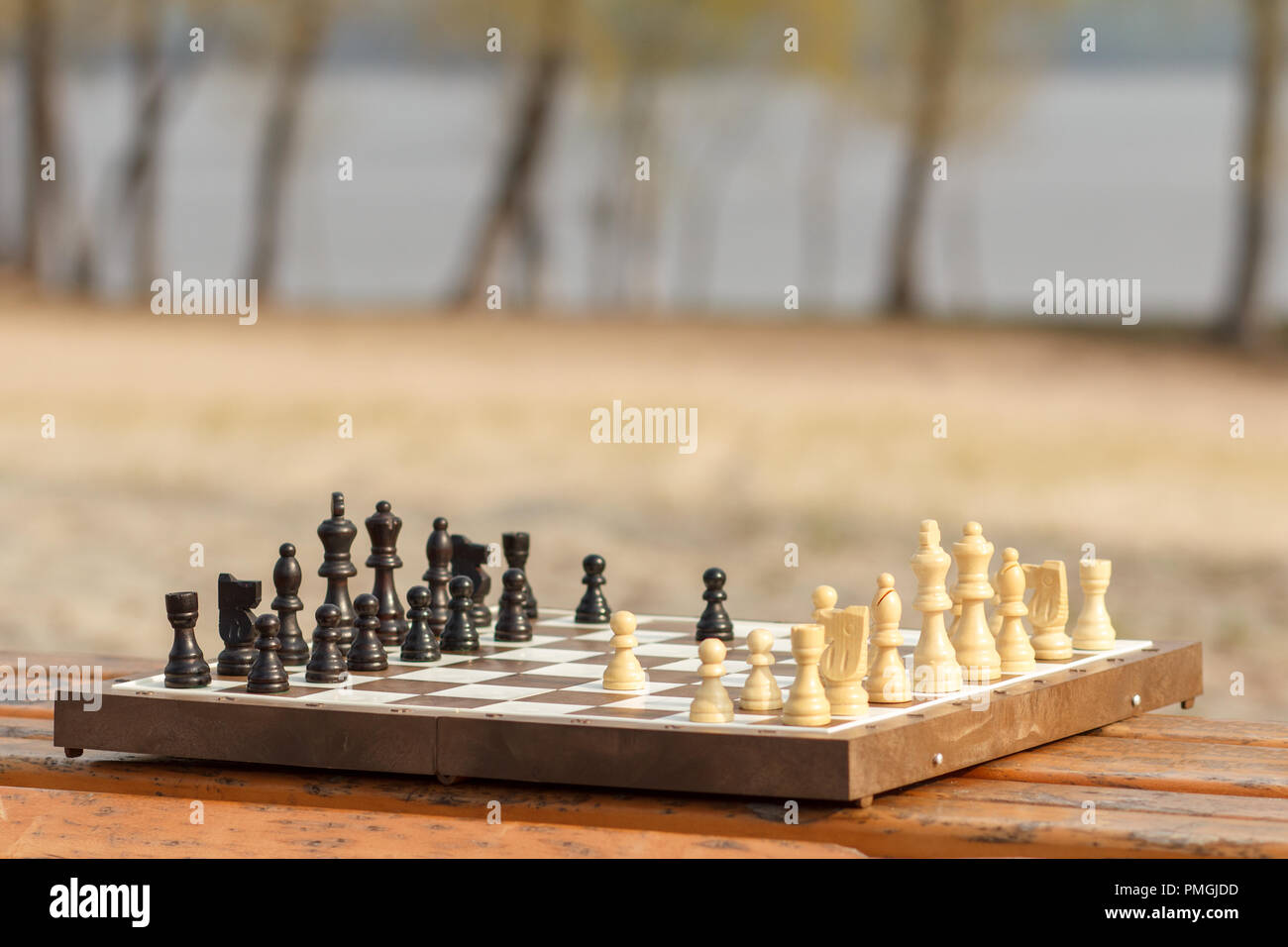 Tablero de ajedrez con piezas de ajedrez sobre el banco de madera. Juego de  ajedrez al aire libre Fotografía de stock - Alamy