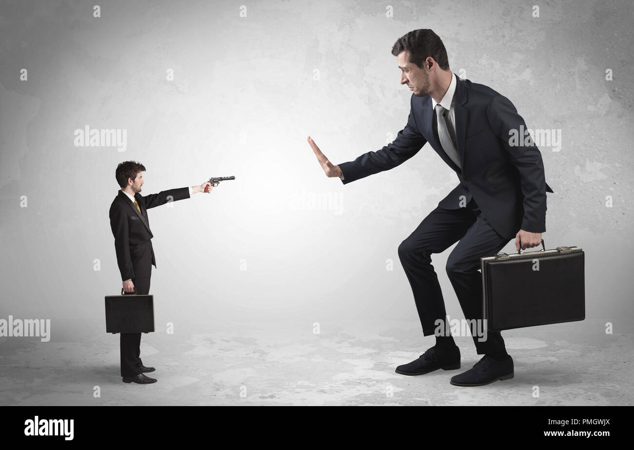 Pequeño empresario con tiroteos gigante empresario temeroso Foto de stock