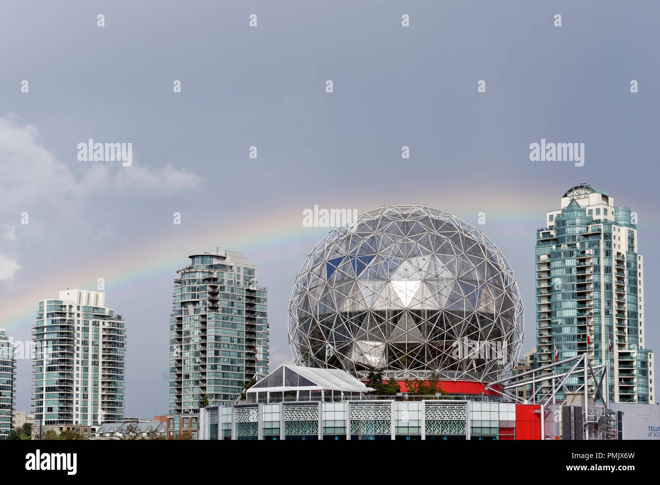 Arco iris sobre Telus World of Science, cúpula geodésica y edificios de apartamentos de gran altura, Vancouver, Columbia Británica, Canadá Foto de stock
