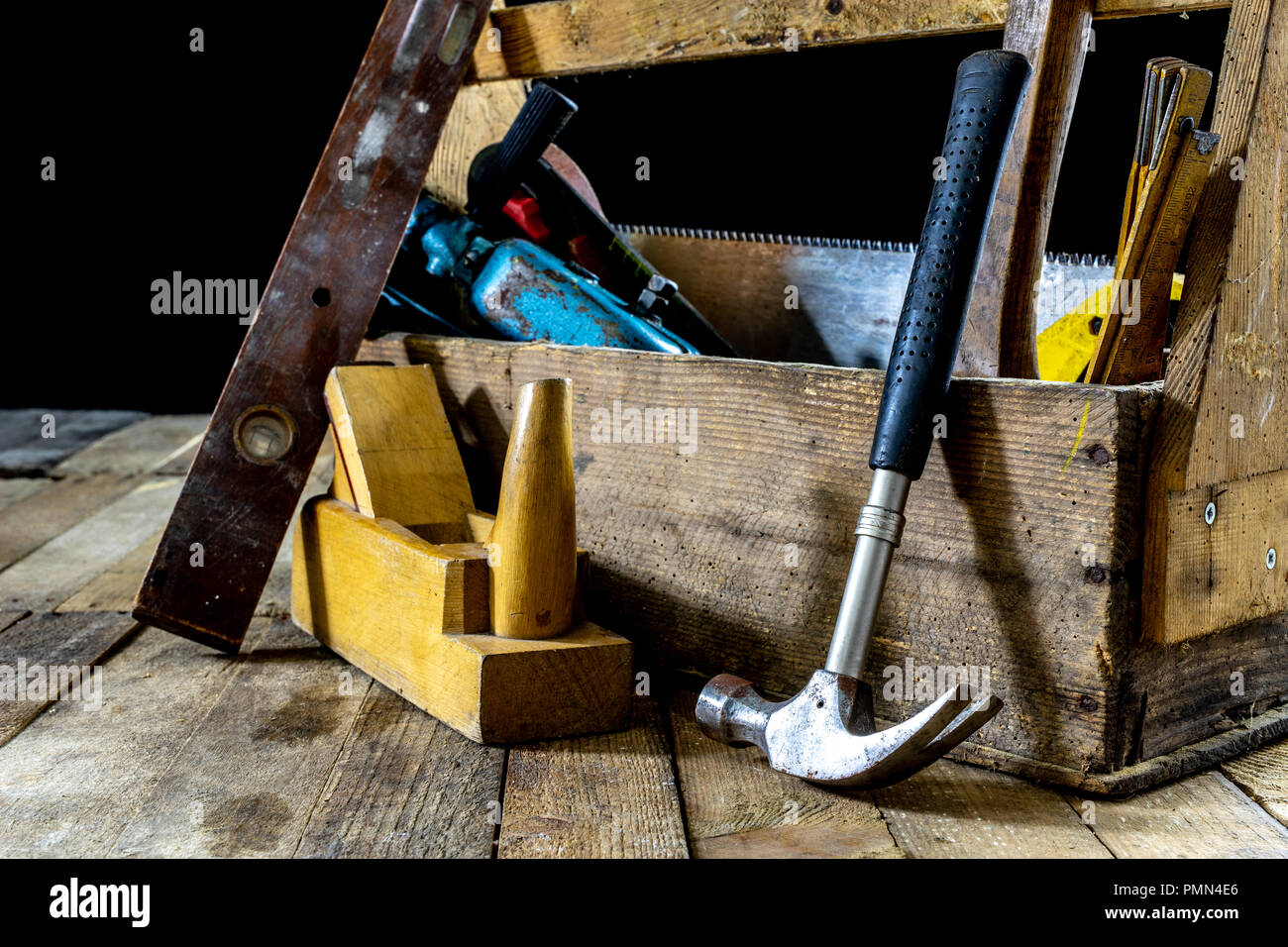 Caja con accesorios para el carpintero. Las herramientas de la carpintería  en una caja en un taller de madera de tabla. Fondo oscuro Fotografía de  stock - Alamy