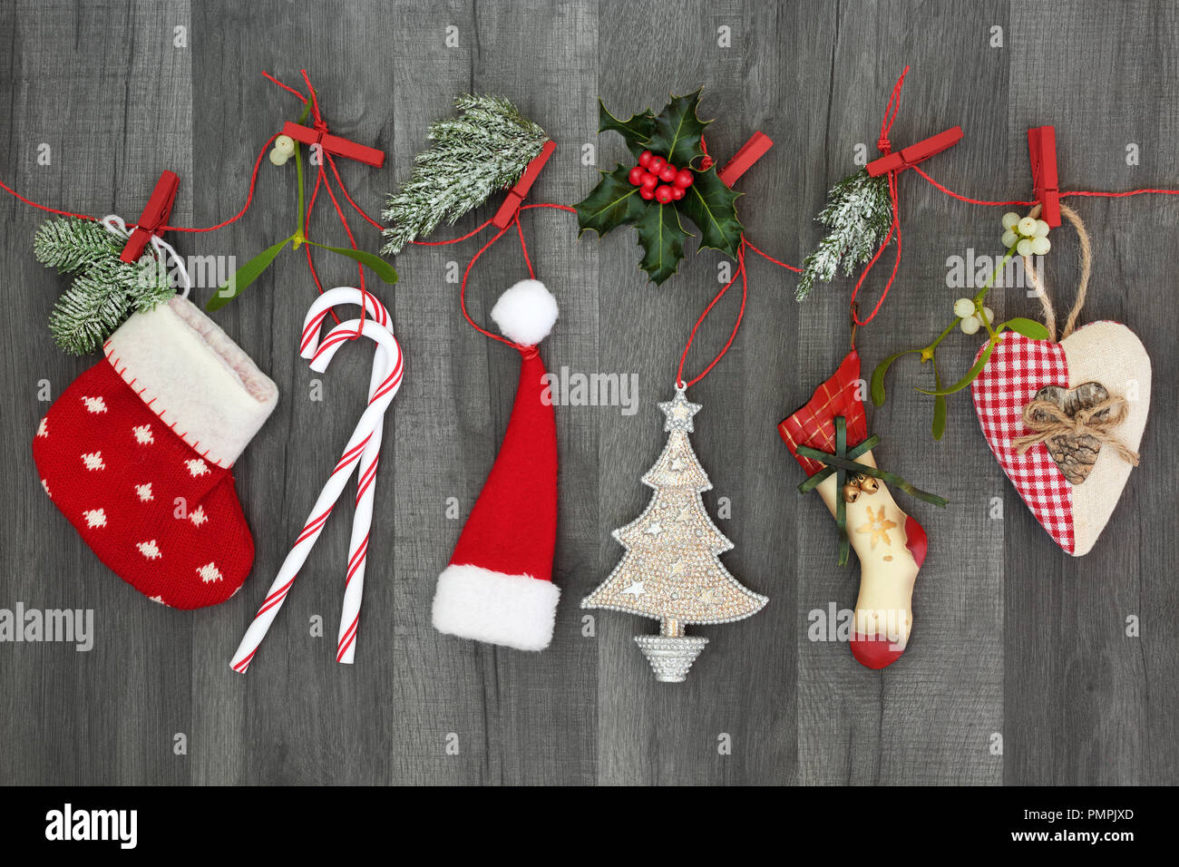 Adornos de Navidad Adornos colgando de un hilo con espigas y flora invierno  cubierto de nieve sobre fondo de madera rústica. Tarjeta navideños  Fotografía de stock - Alamy