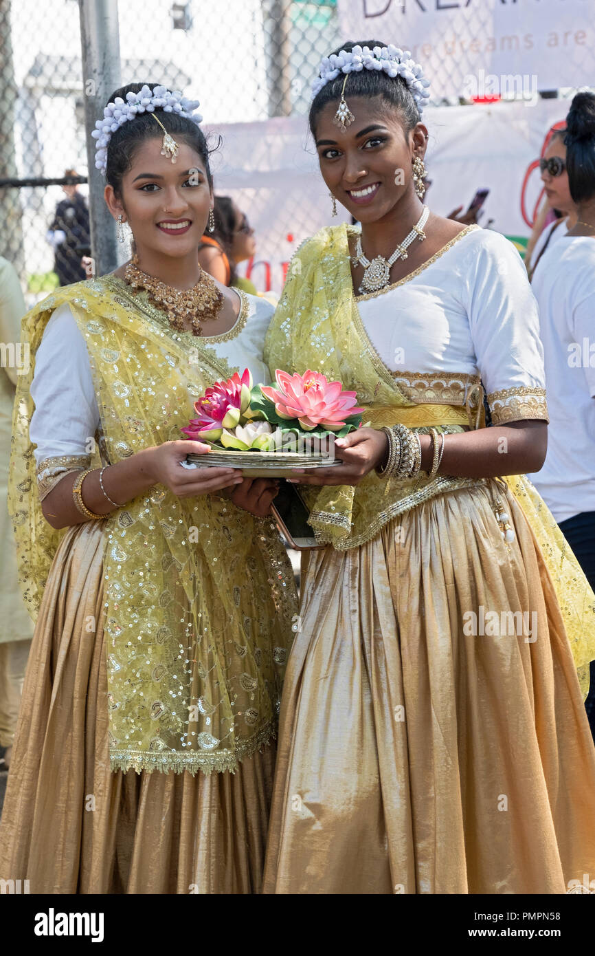 Plantea el retrato de 2 hermosas señoritas sosteniendo flores en el 2018 Madrassi desfile en Richmond Hill, Queens, Nueva York. Foto de stock