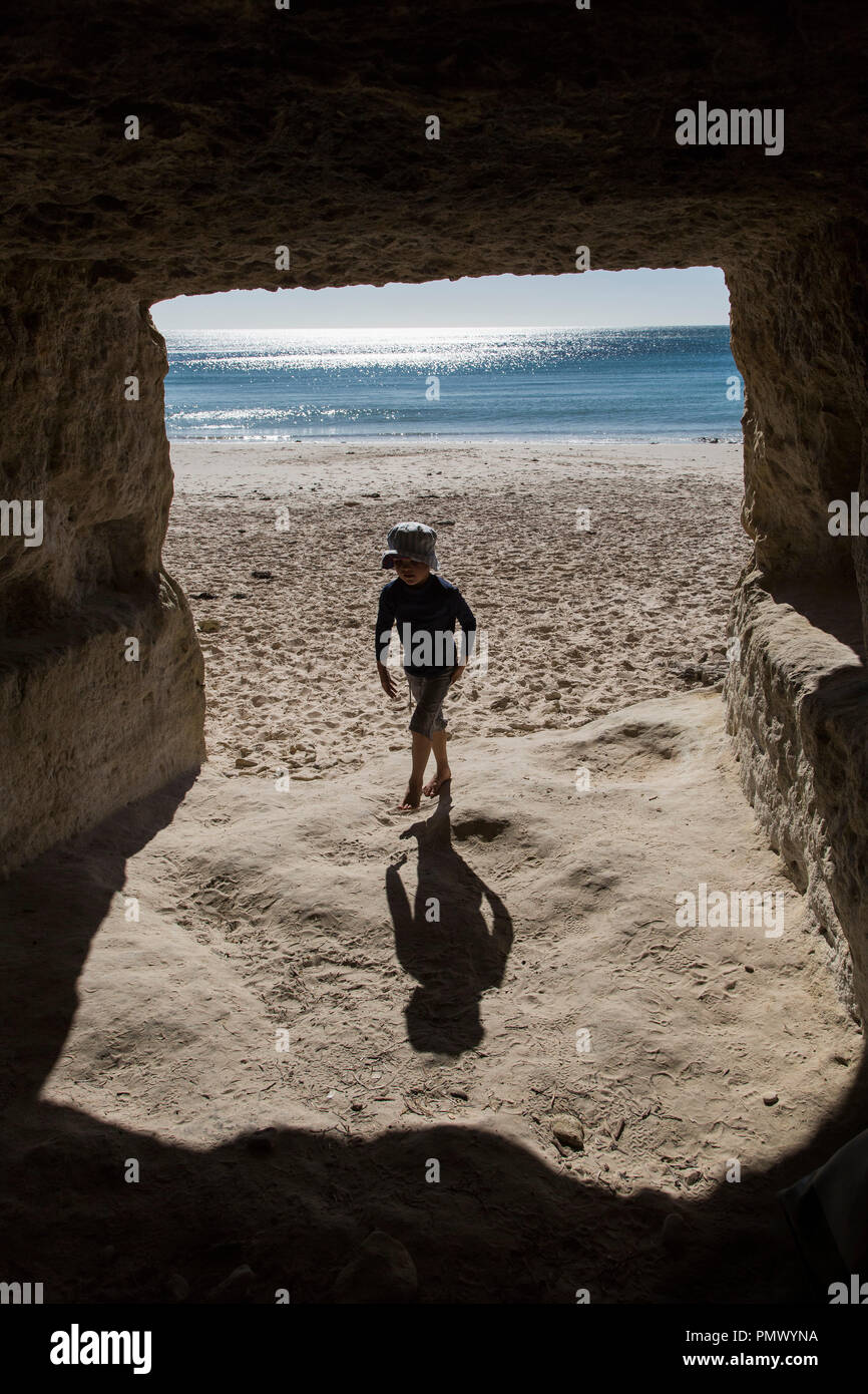 Chico sunny ocean beach pasear en cueva Foto de stock