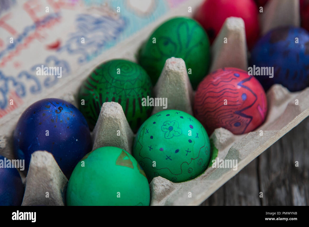 Cerca de huevos de Pascua de colores vibrantes en cartón Foto de stock