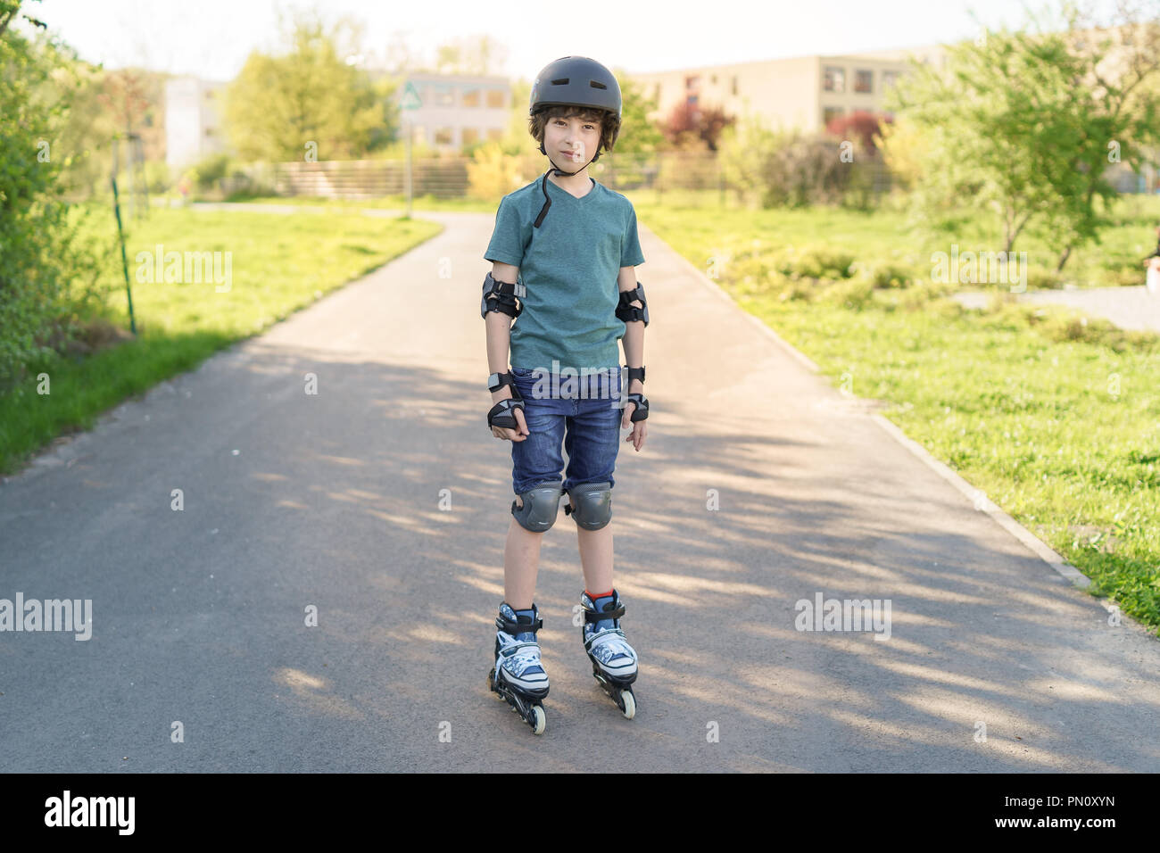 Retrato de un niño sobre rodillos en un casco protector, rodilleras y  coderas Fotografía de stock - Alamy