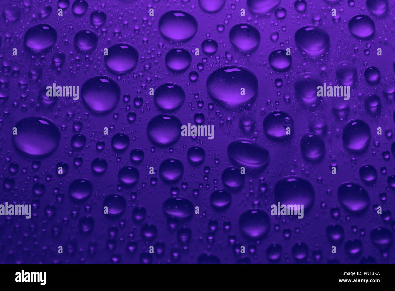 Gotas de agua en el fondo de color azul violeta cerca de textura Fotografía  de stock - Alamy