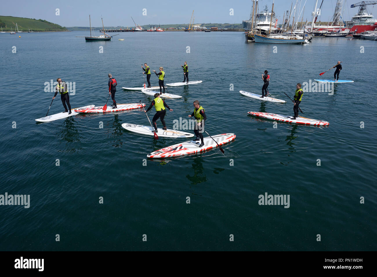 Paddle snowboarders en Falmouth Harbour, Cornwell, Inglaterra Foto de stock