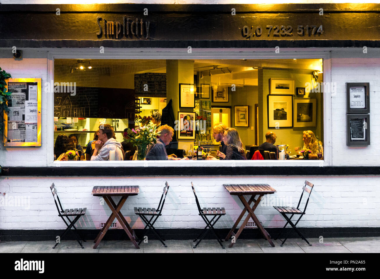 La gente cenando en un restaurante con una gran ventana, simplicidad Restaurante en Rotherhithe, Londres, Reino Unido. Foto de stock