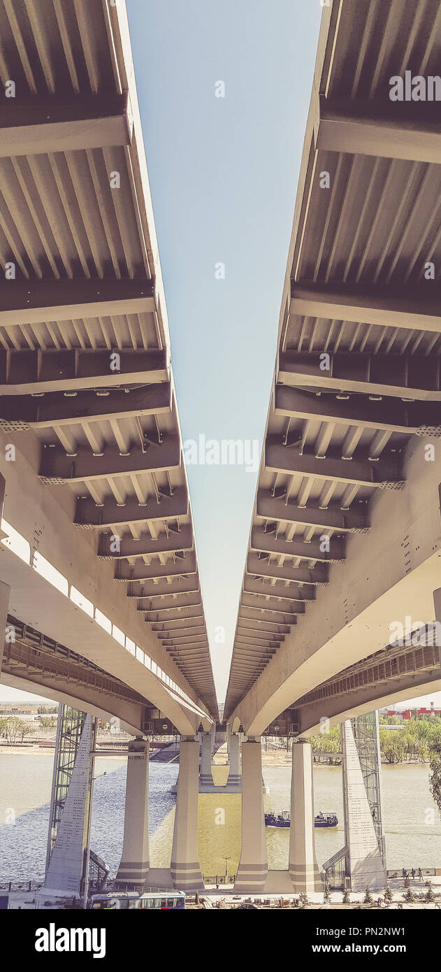 Vista bajo el nuevo puente moderno. Autopista que conduce al otro lado del río Foto de stock