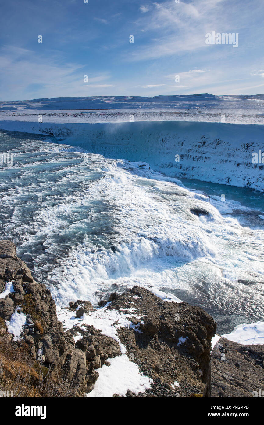 Brota el agua del río glacial en caídas de la cascada de Gullfoss y las montañas en el paisaje glacial del sur de Islandia Foto de stock