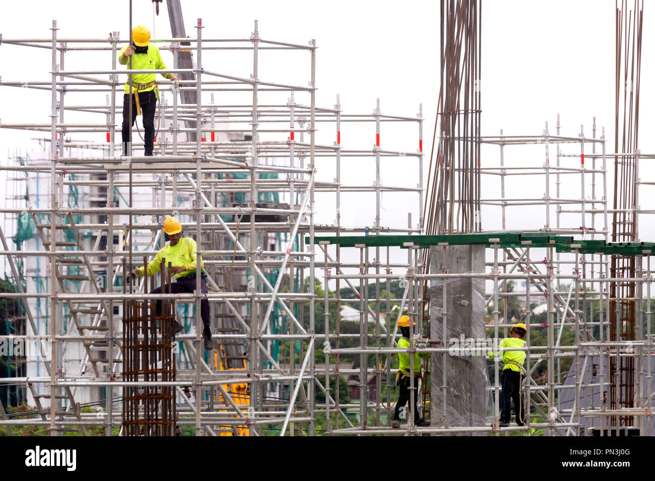 Los trabajadores de la construcción de asia trabaja en un andamio de sitio de construcción en la ciudad. La expansión urbana de la ciudad capital de Asia están creciendo más rápidamente Foto de stock