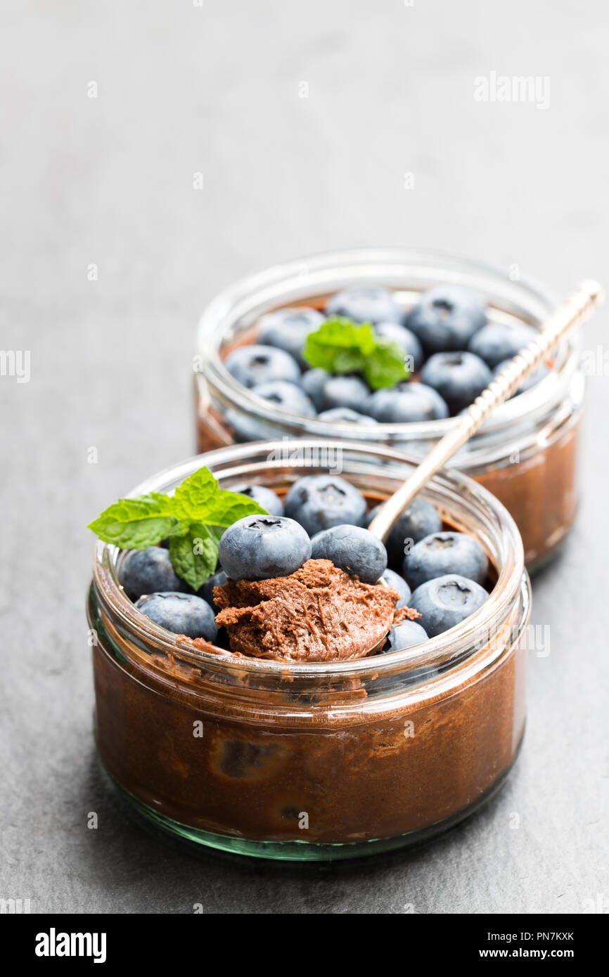 Mousse de chocolate praliné con bayas sobre fondo de piedra negra Foto de stock