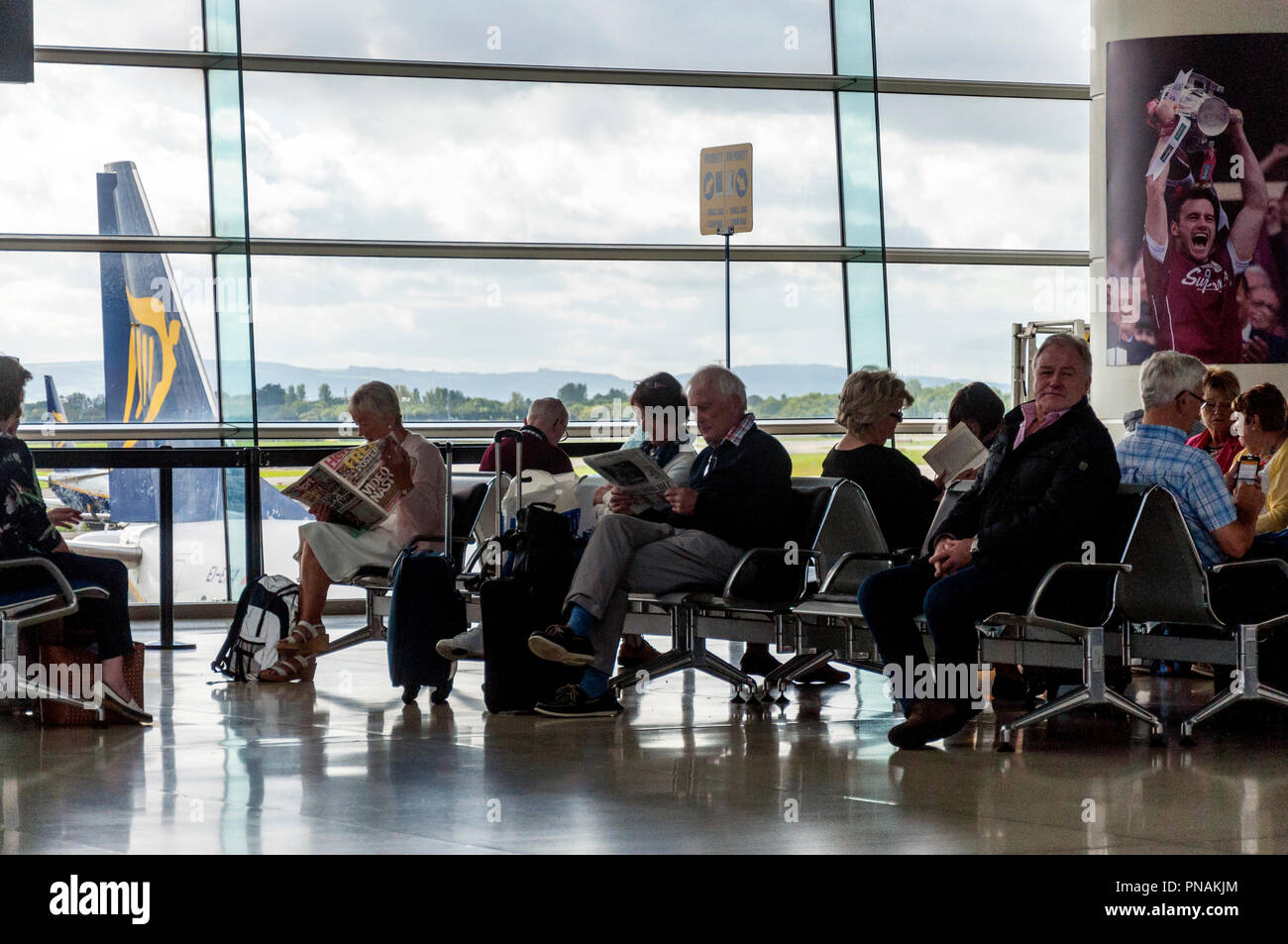 El aeropuerto de Dublín, Irlanda. Los pasajeros esperar a bordo de un vuelo sentarse en las puertas de embarque de la Terminal 1. Foto de stock