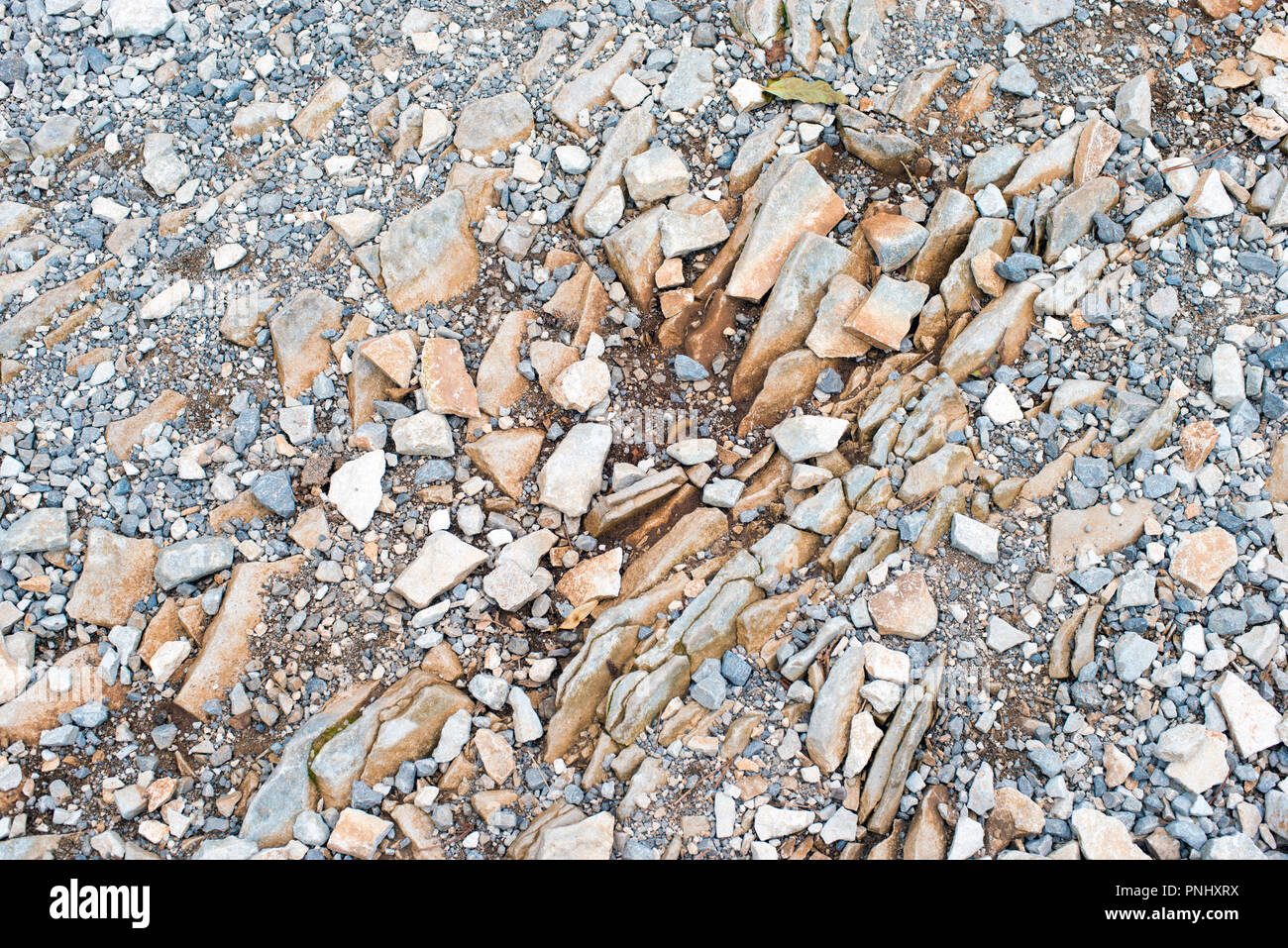 Muchas piedras en la tierra rocosa de pizarra de carretera de montaña Foto de stock