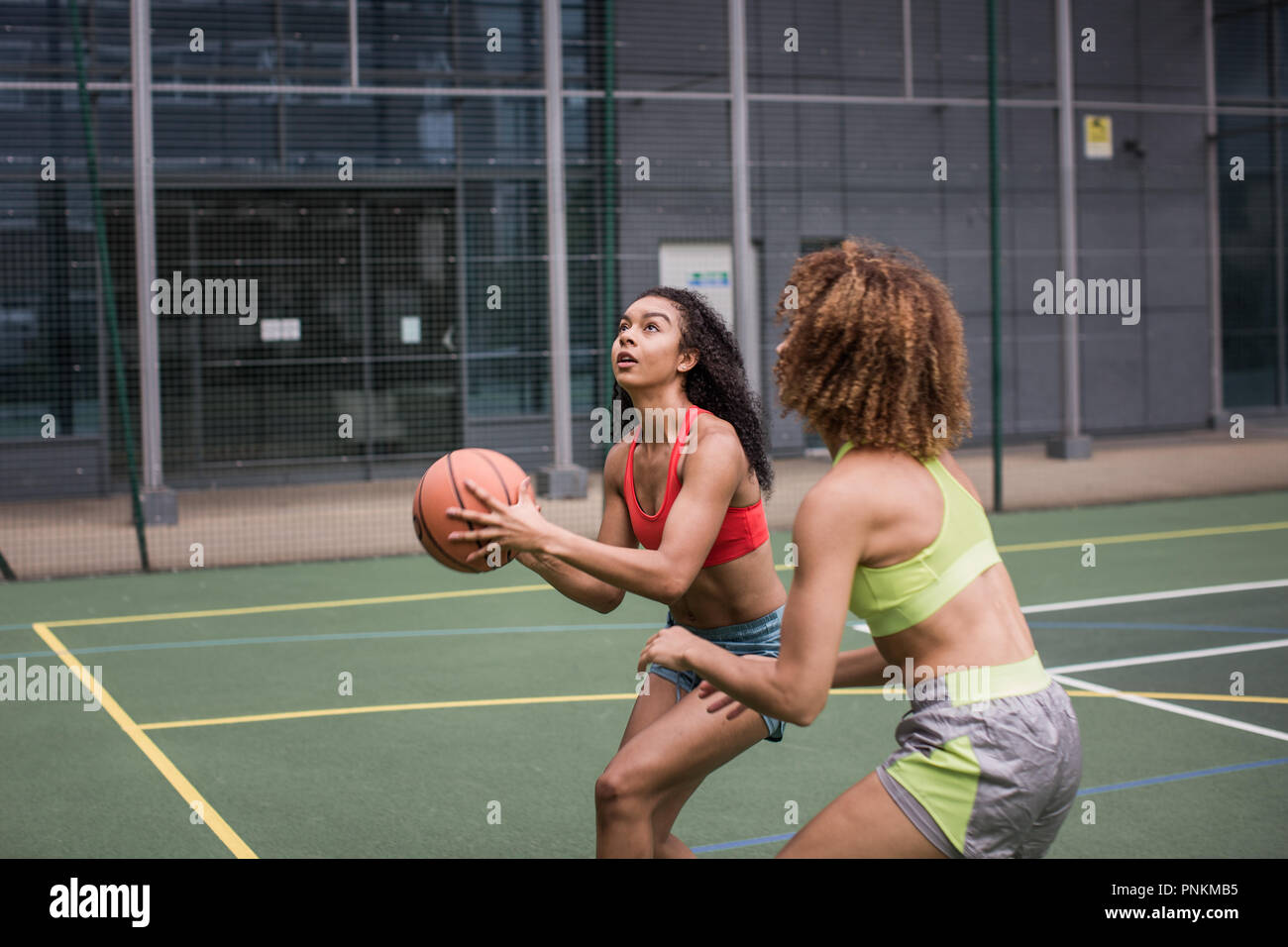 Adulto joven jugador de baloncesto femenino va a rodar un aro Foto de stock