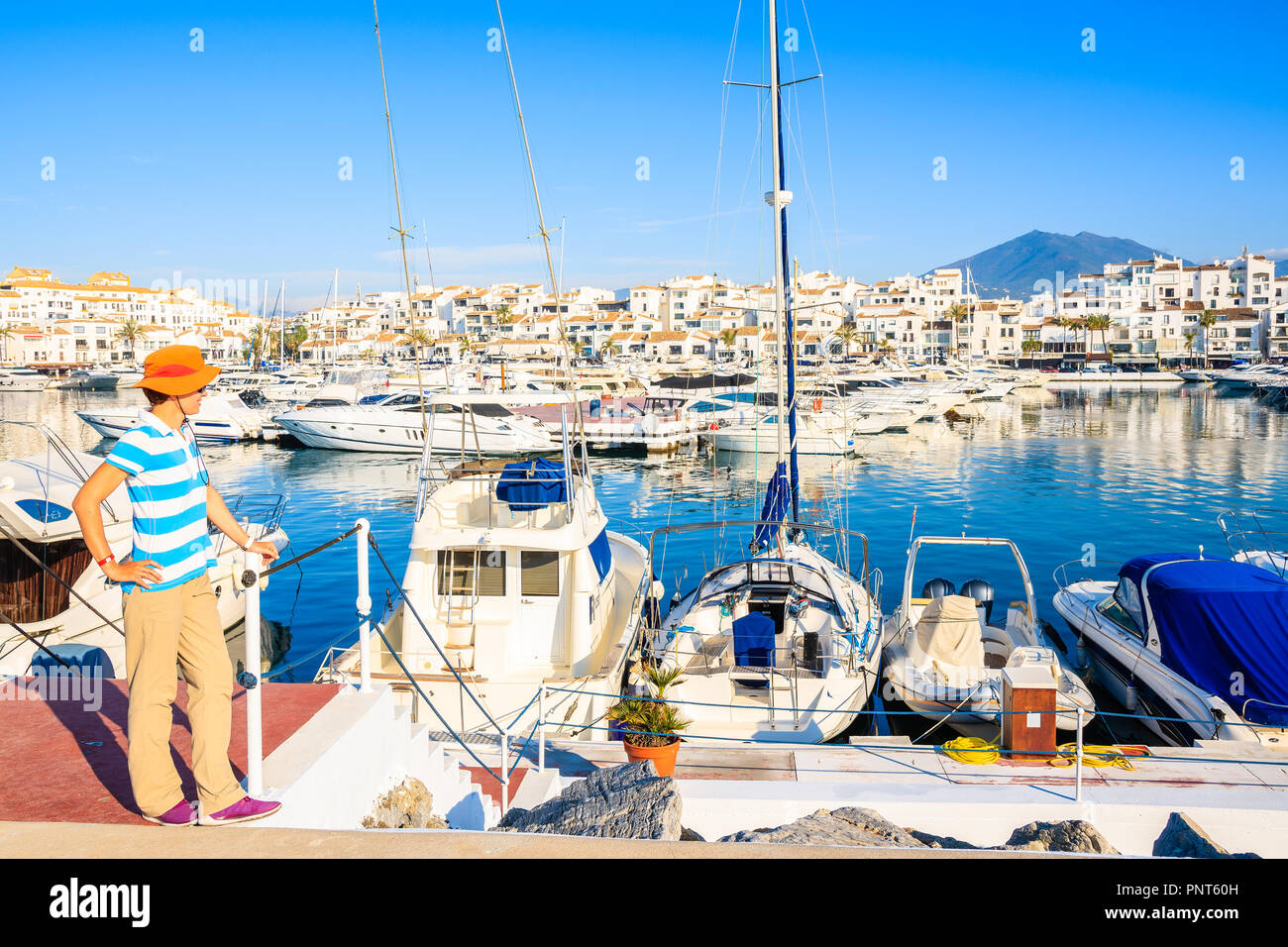 Joven turista mirando Puerto Banus con botes y casas blancas en la ciudad de Marbella, en Andalucía, España Foto de stock