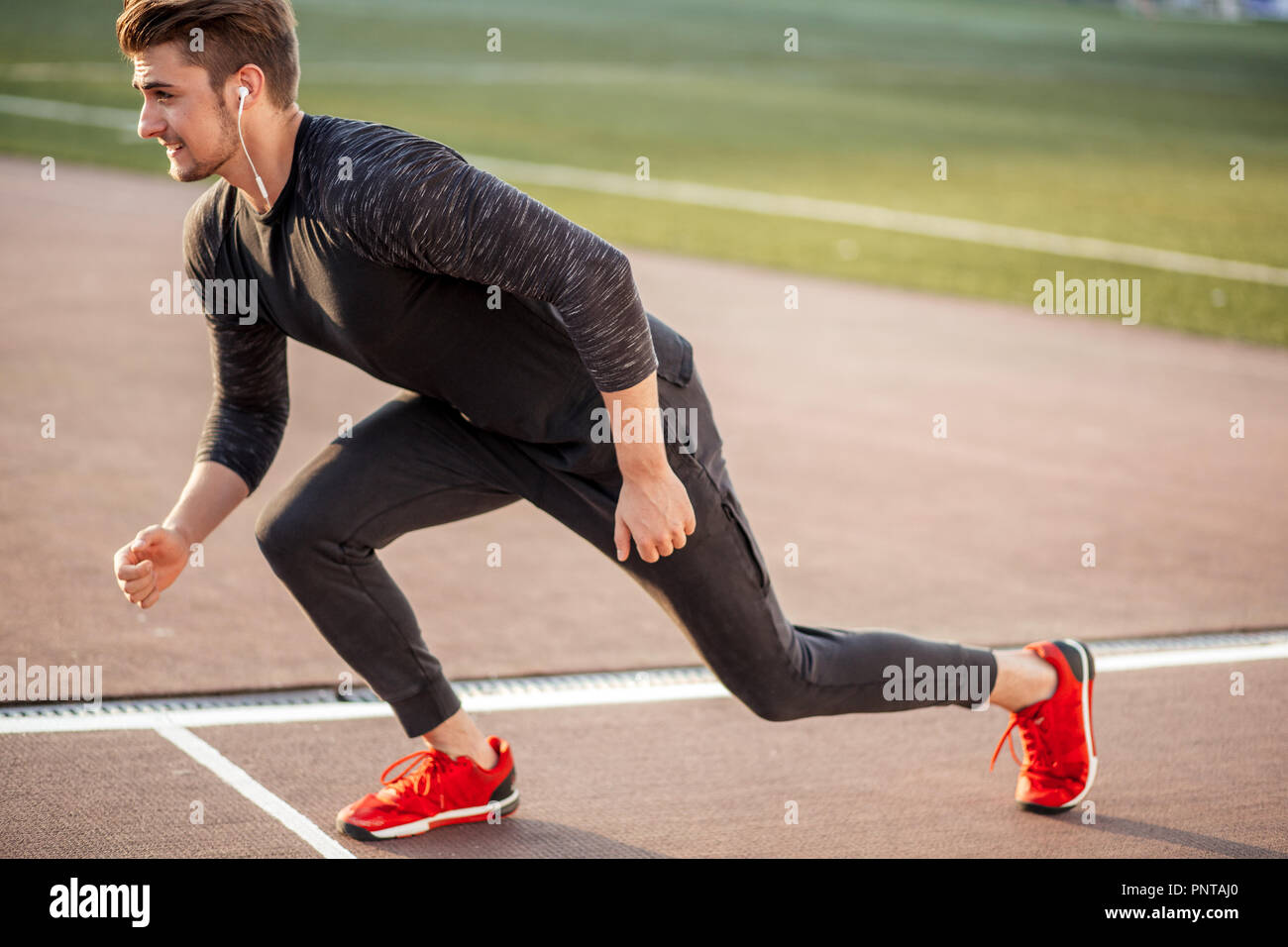 Atleta vestidos de negro a partir de sprint en pista de atletismo  Fotografía de stock - Alamy