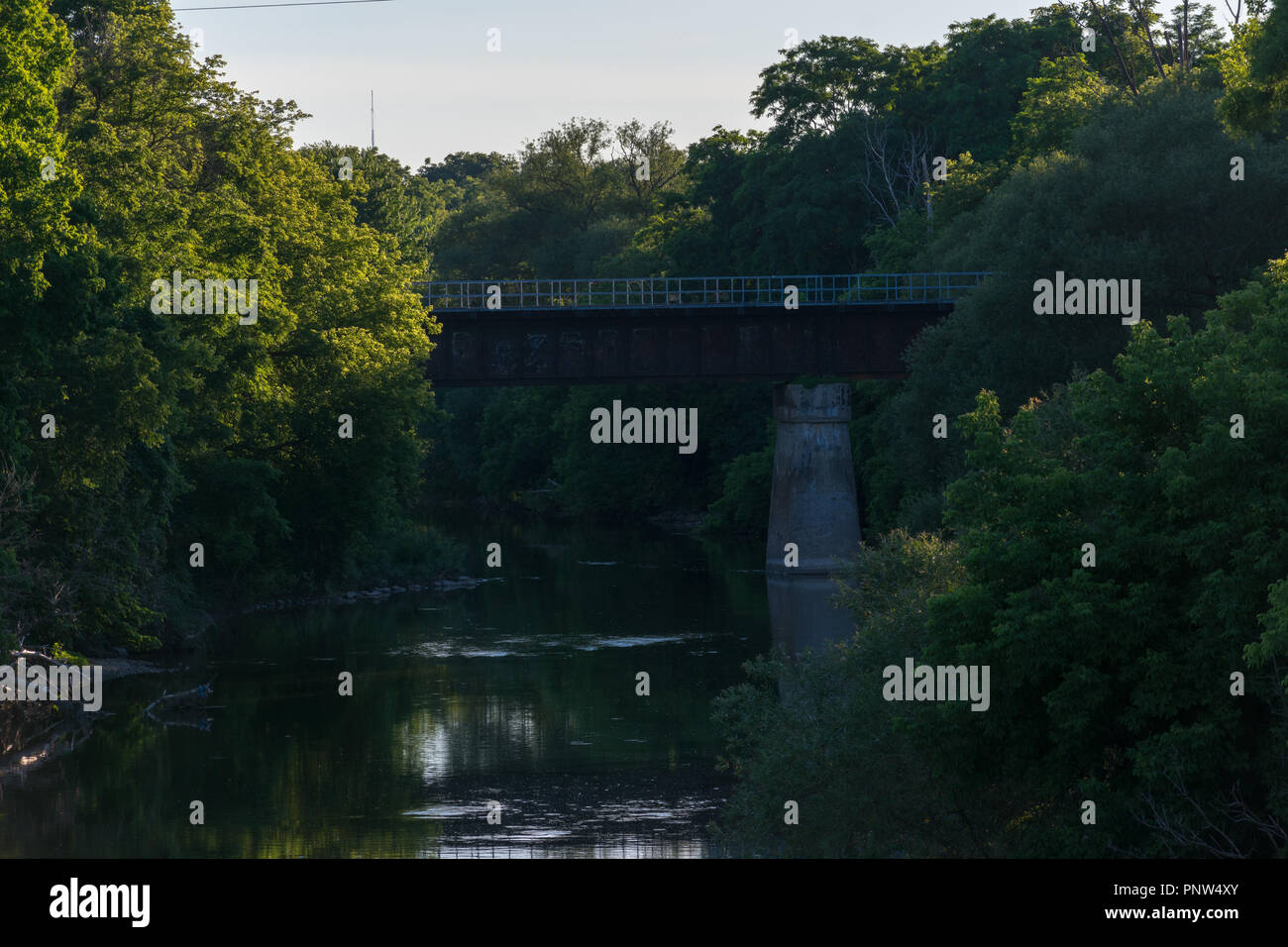 Un tranquilo río que fluye como un puente custodia Foto de stock