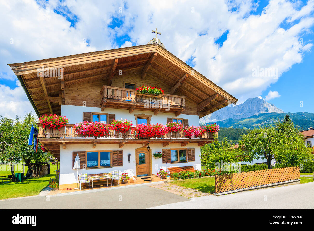 Casa alpina tradicional con balcones decorados con flores en ir am Wilden Kaiser Mountain Village, Alpes Kitzbuhel, Austria Foto de stock